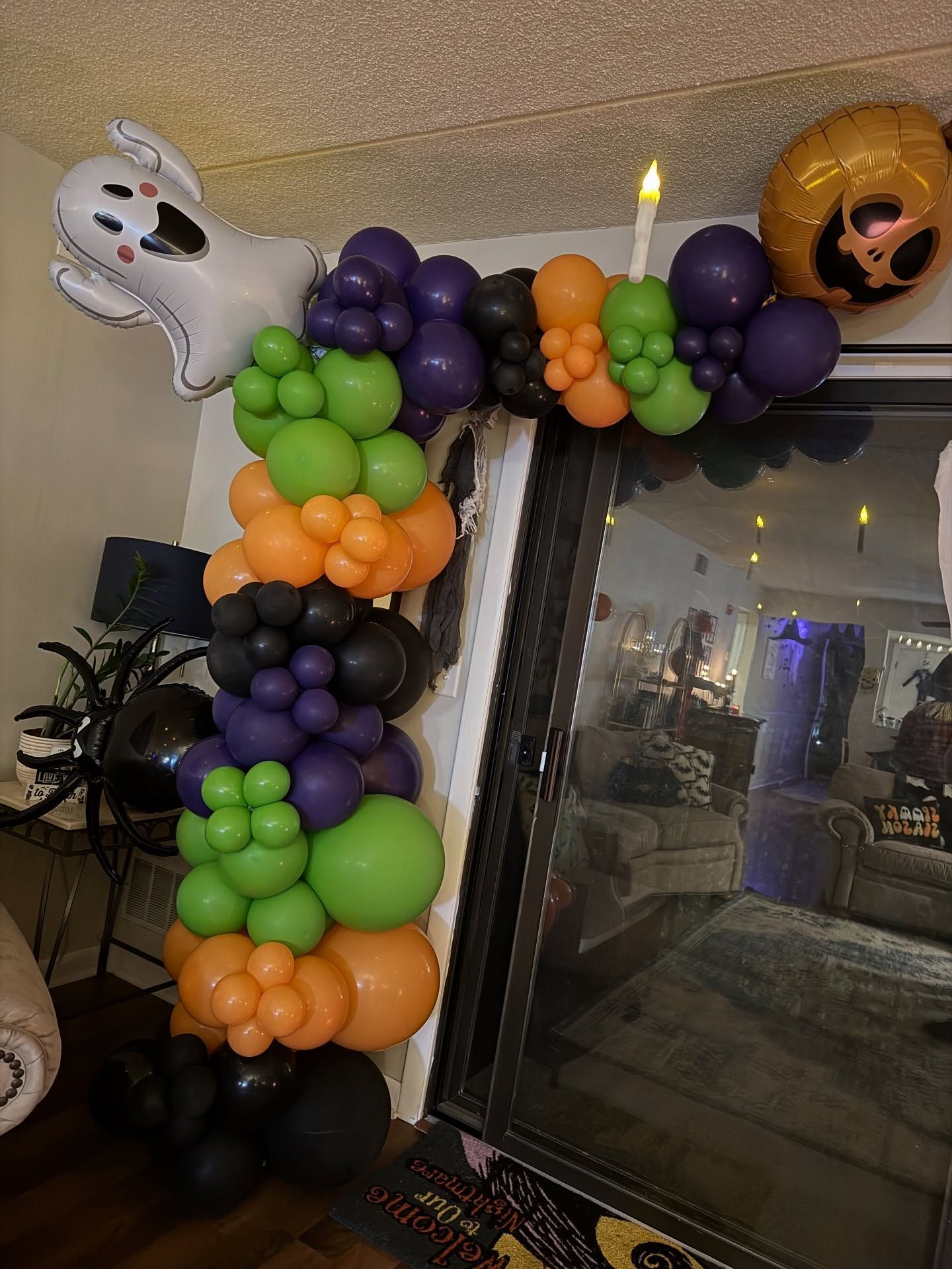 Halloween balloon arch with ghosts and pumpkins framing a doorway