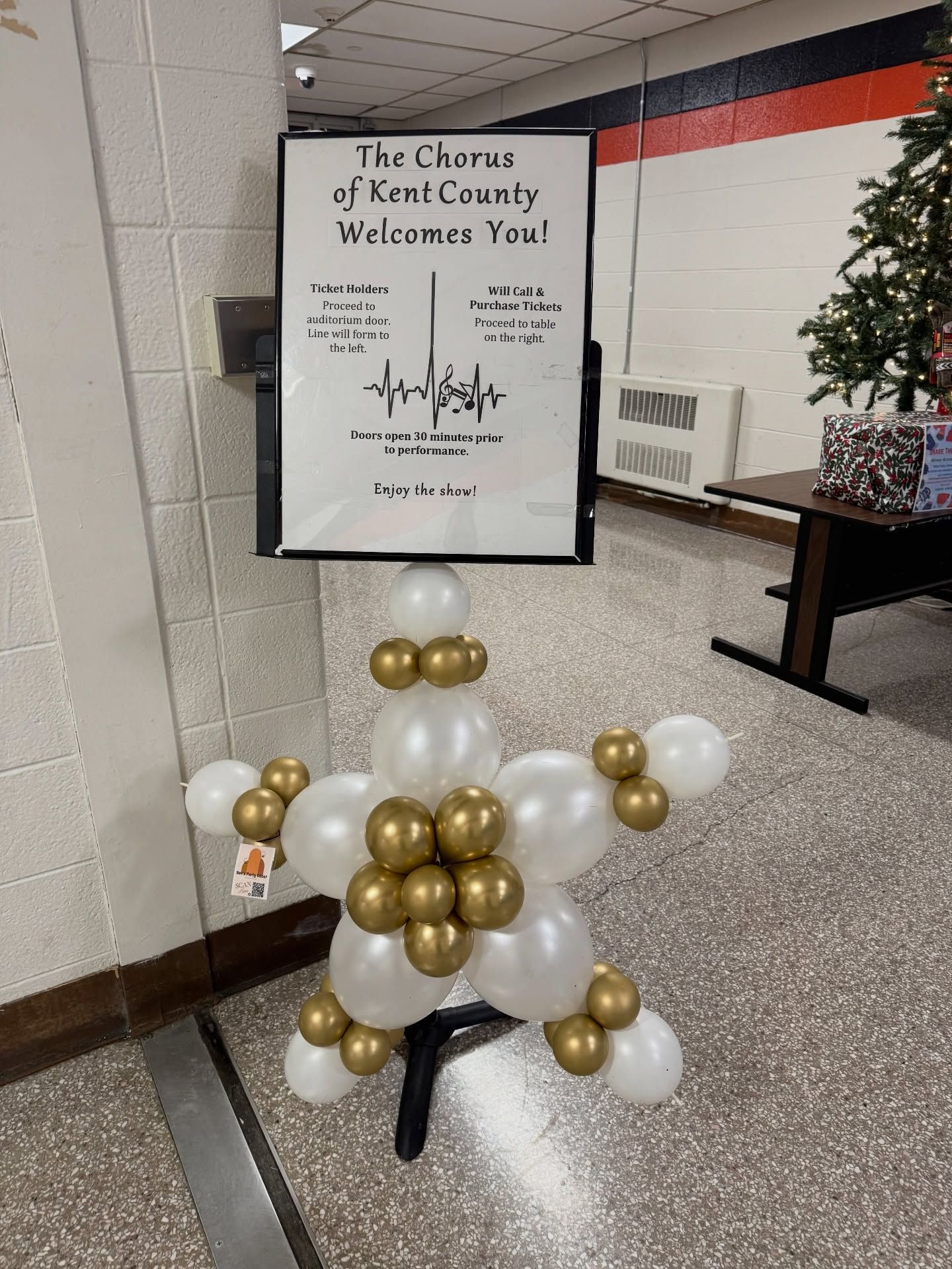 Welcome sign with gold-and-white balloon arrangement in a hallway