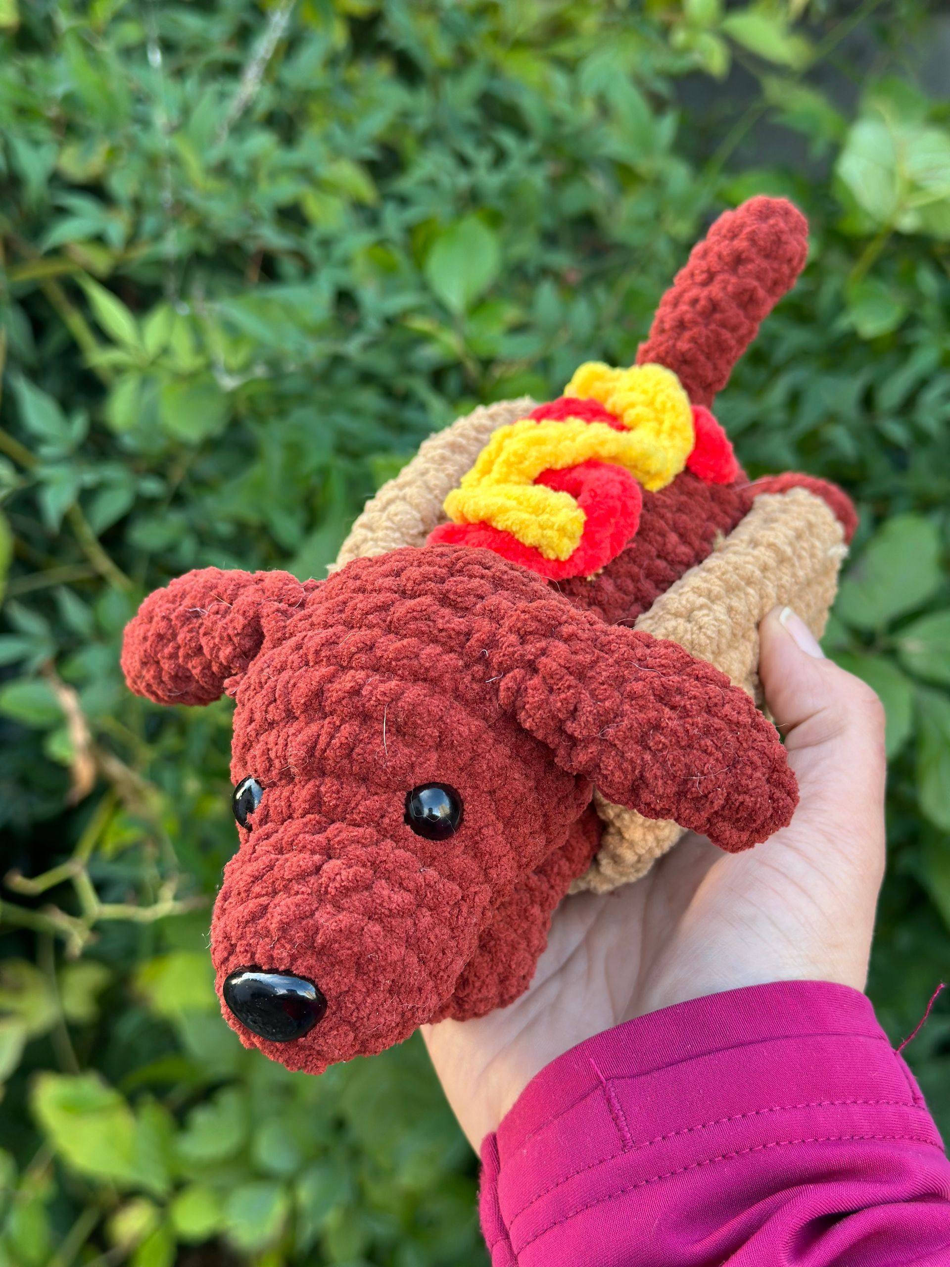 Crochet hot dogs with brown dachshund heads, tan buns, red wieners, and yellow/red condiments.