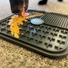 Black dog lick mat with recipe guide and spatula.