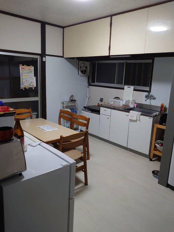 A kitchen with a table and chairs and a refrigerator.