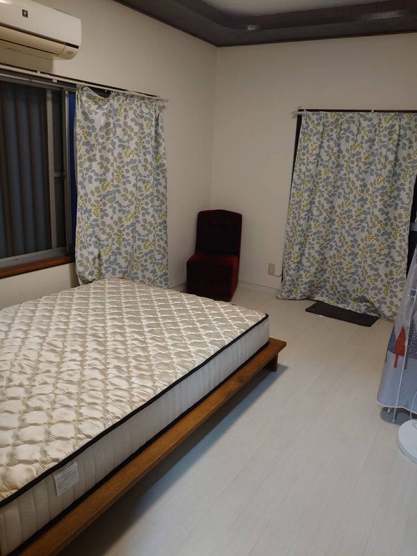 A bedroom with a mattress and a chair in it