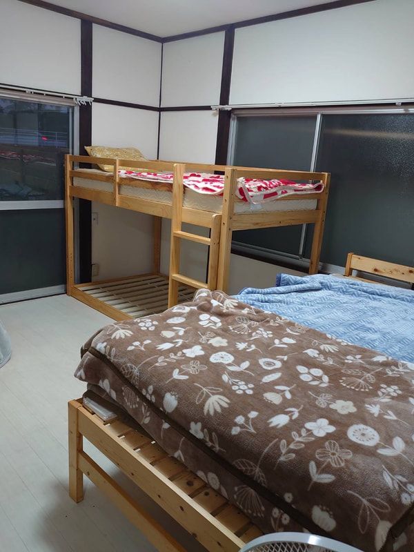A bedroom with two bunk beds and a fan