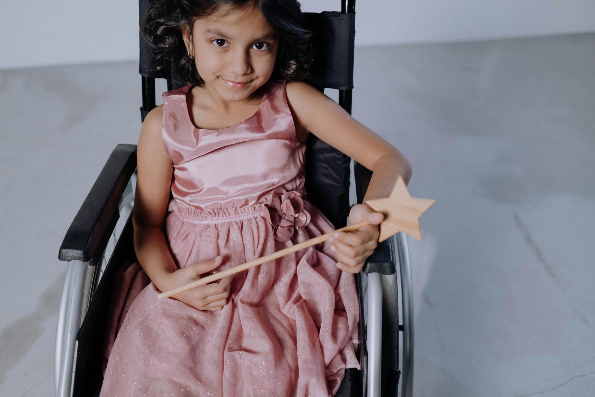 image of child in a wheelchair with a fairy dress and wand