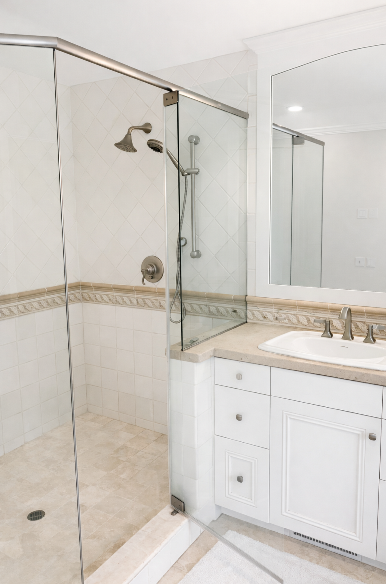 Modern bathroom with glass shower, white vanity, and large mirror