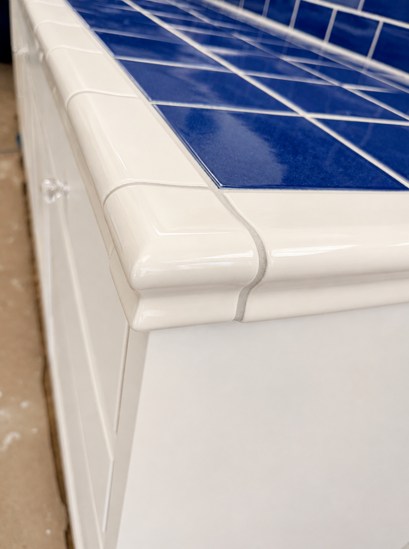 White roof edge detail beside blue solar panels on a building