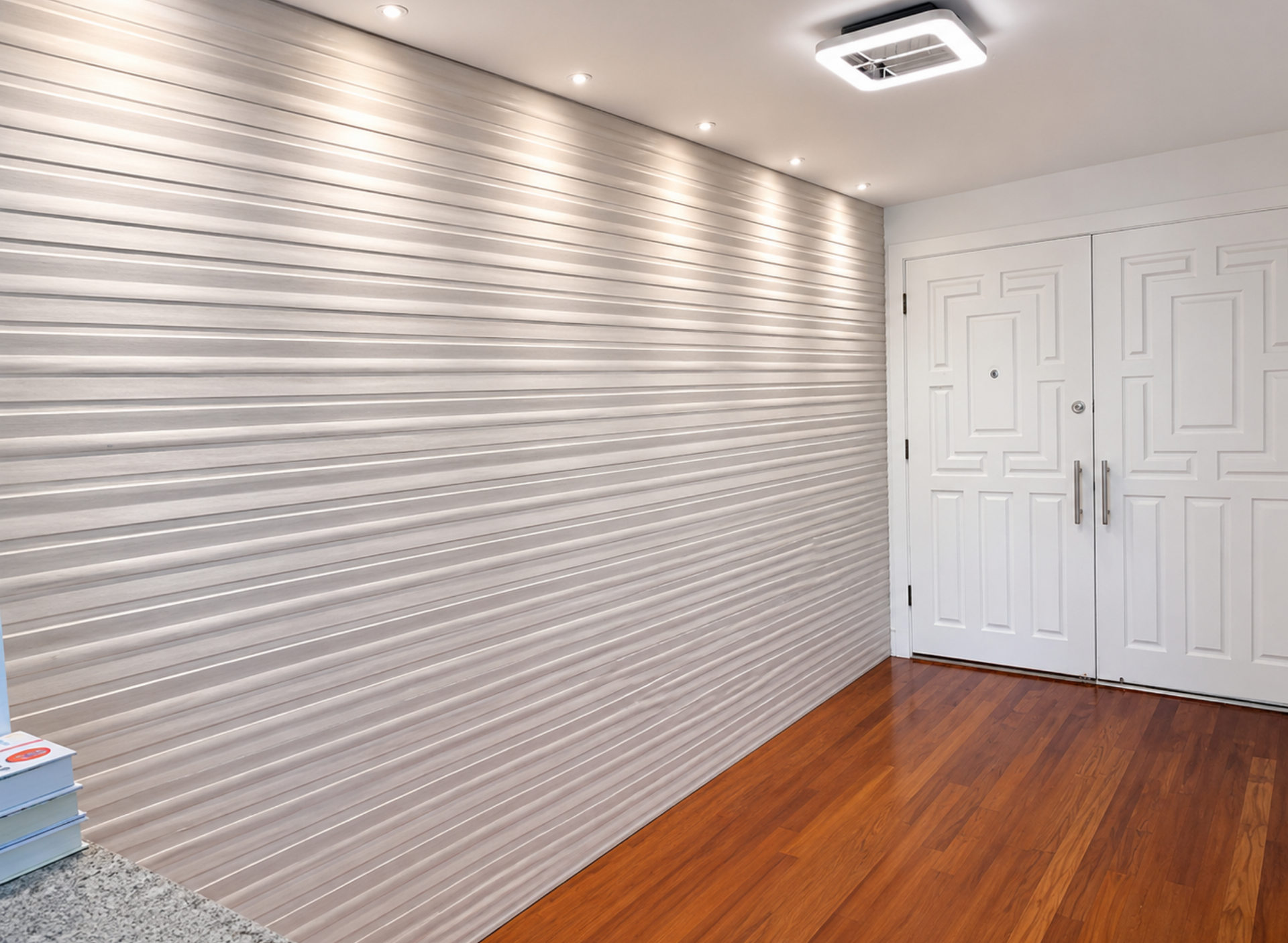 Empty modern room with textured white wall, geometric white double doors, and wood flooring.