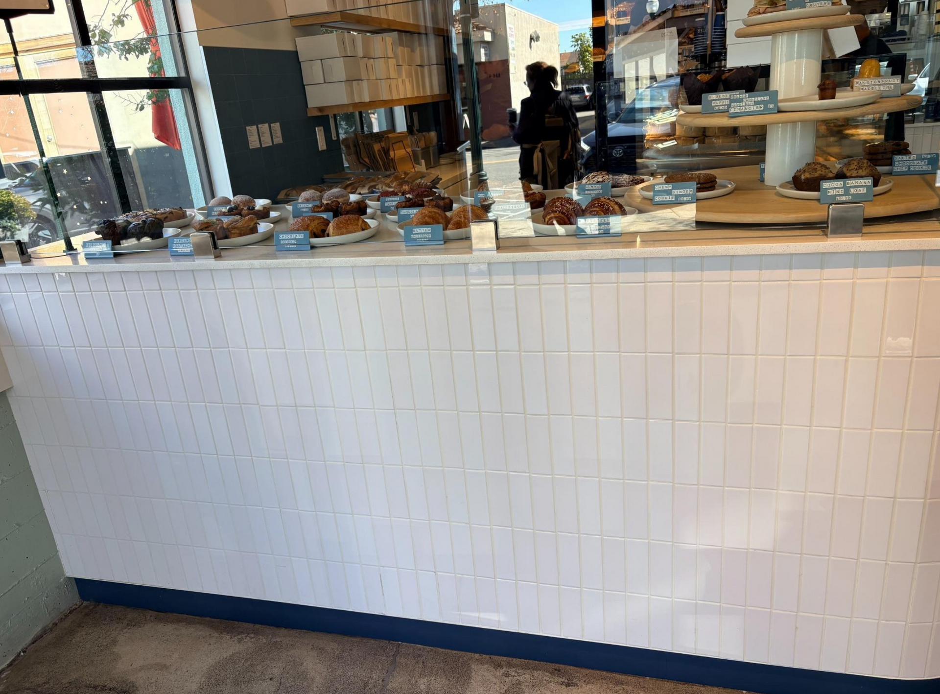 Bakery display counter with pastries behind glass in a bright café interior