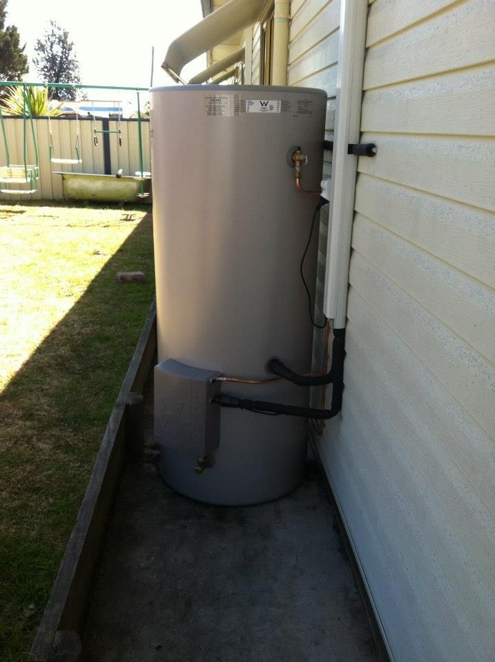 A Large Gray Water Heater is Attached to the Side of a House β Sapphire City Solar & Electrical In Inverell, NSW