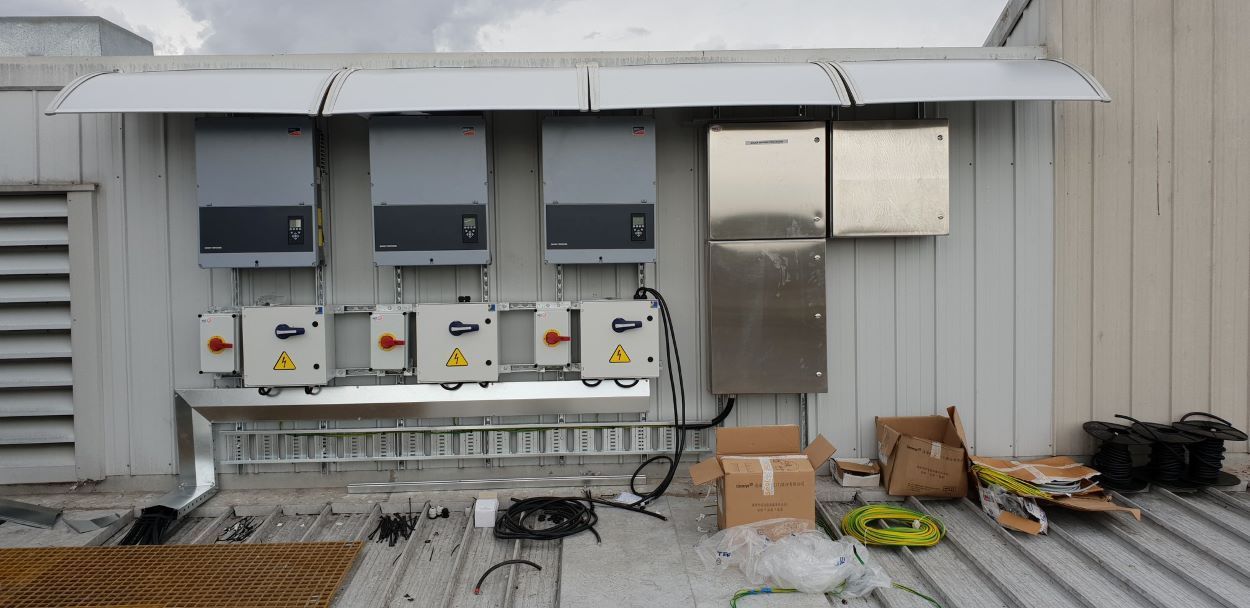 A Row of Electrical Boxes Are Sitting on the Side of a Building — Sapphire City Solar & Electrical In Glen Innes, NSW