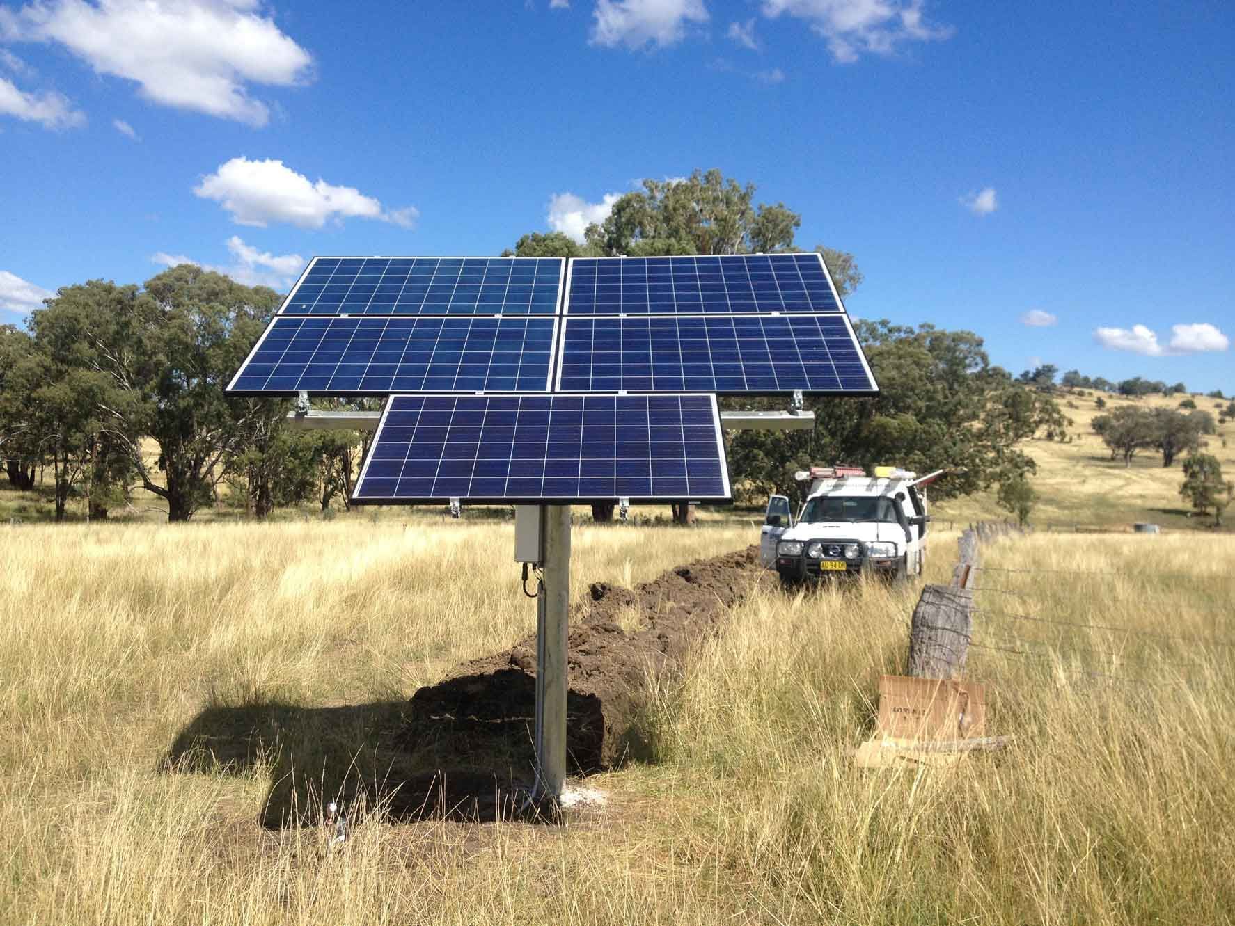 A Man is Sitting on the Roof of a House With Solar Panels on It β Sapphire City Solar & Electrical In Inverell, NSW
