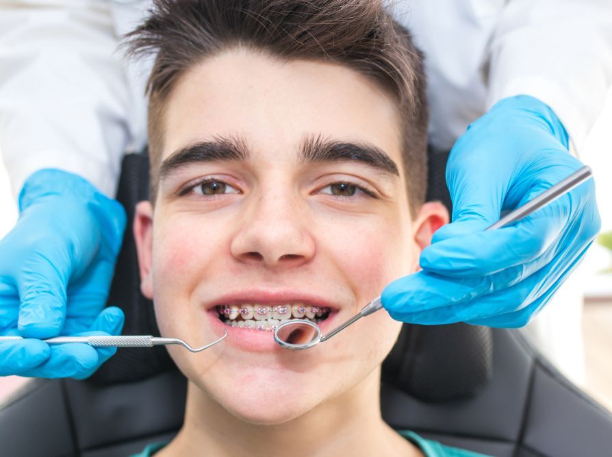 A young boy is getting his teeth examined by a dentist.