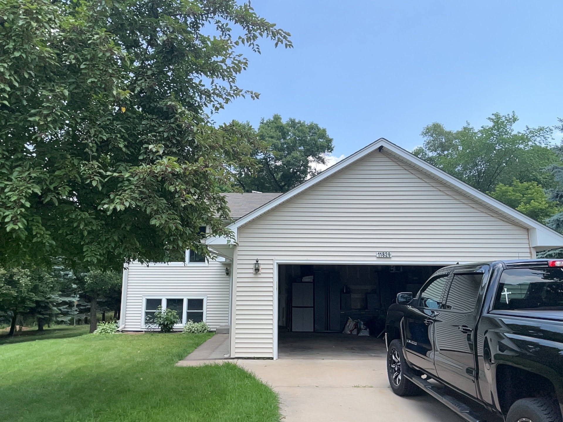 Suburban house with open garage and black pickup truck parked in front
