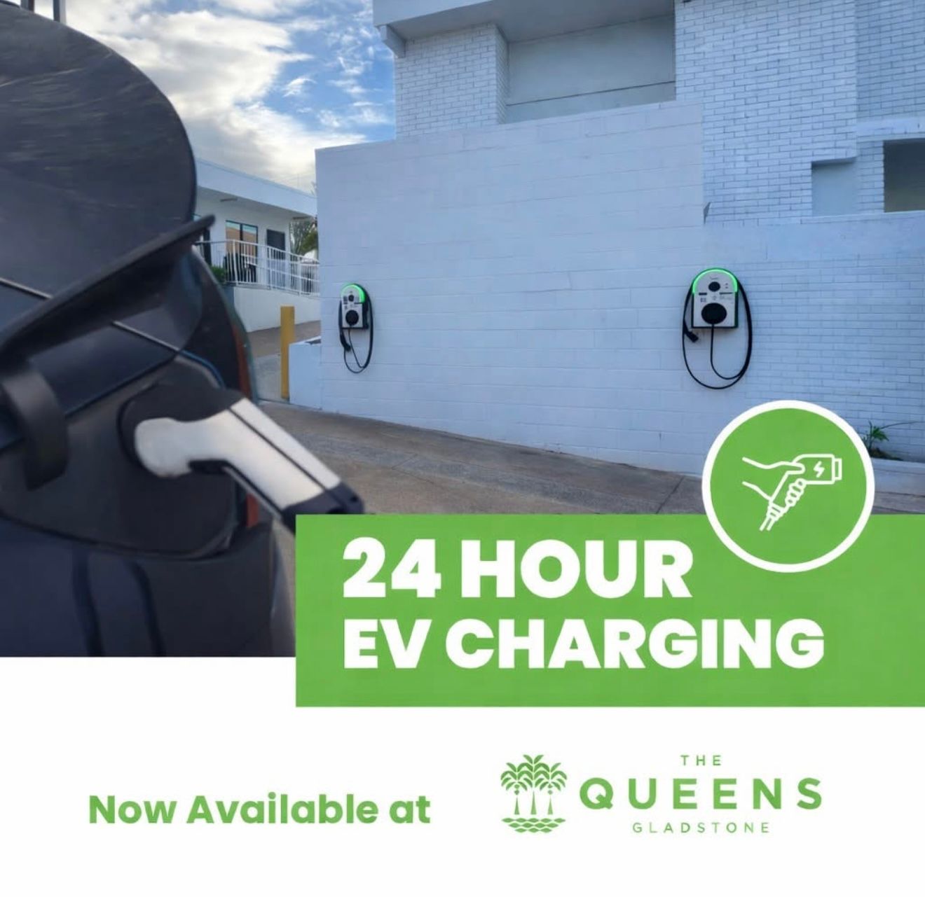 EV charging stations outside a white building with text: “24 HOUR EV CHARGING” and “Now Available at The Queens Gladstone”