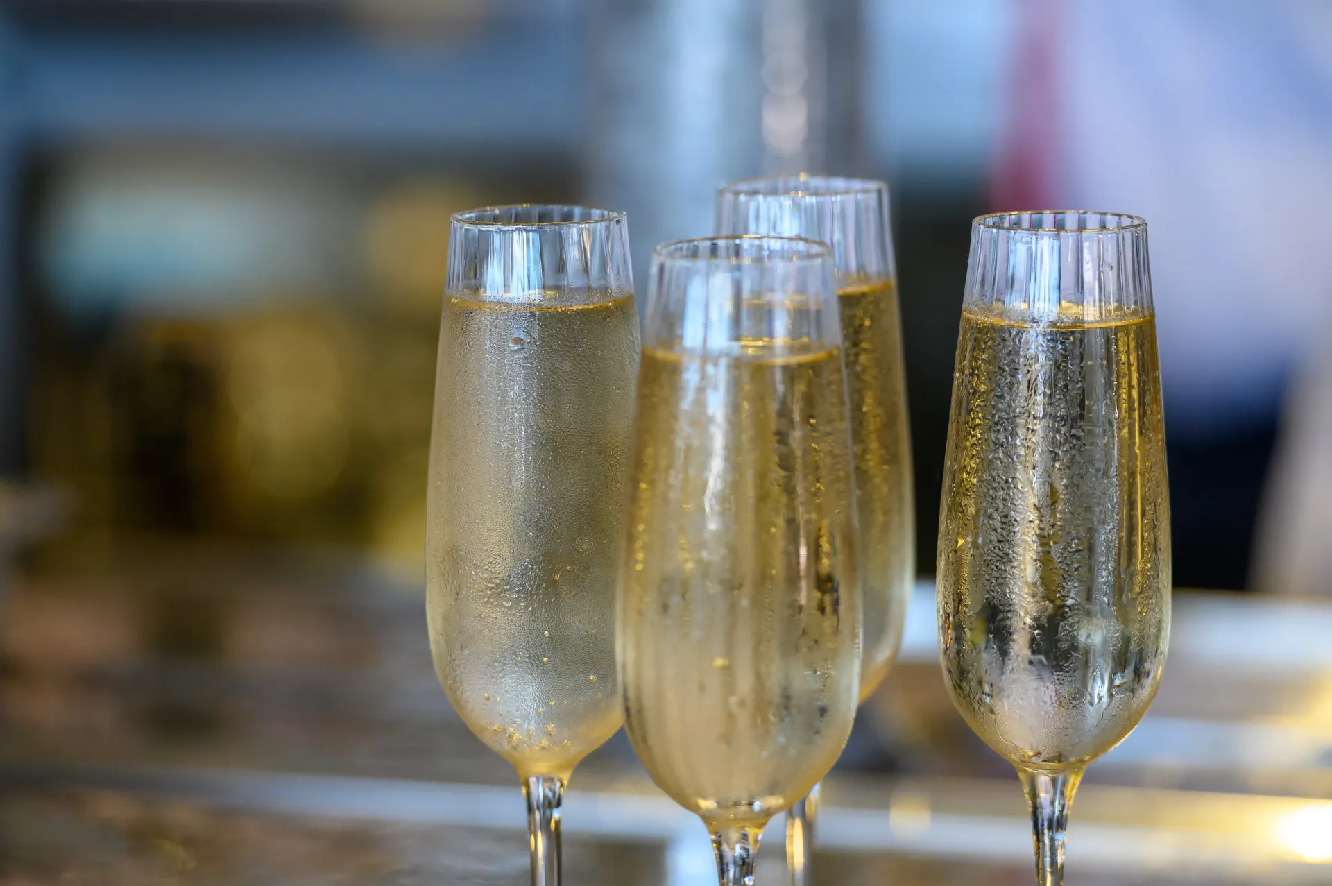 Four glasses of champagne are sitting on a bar.