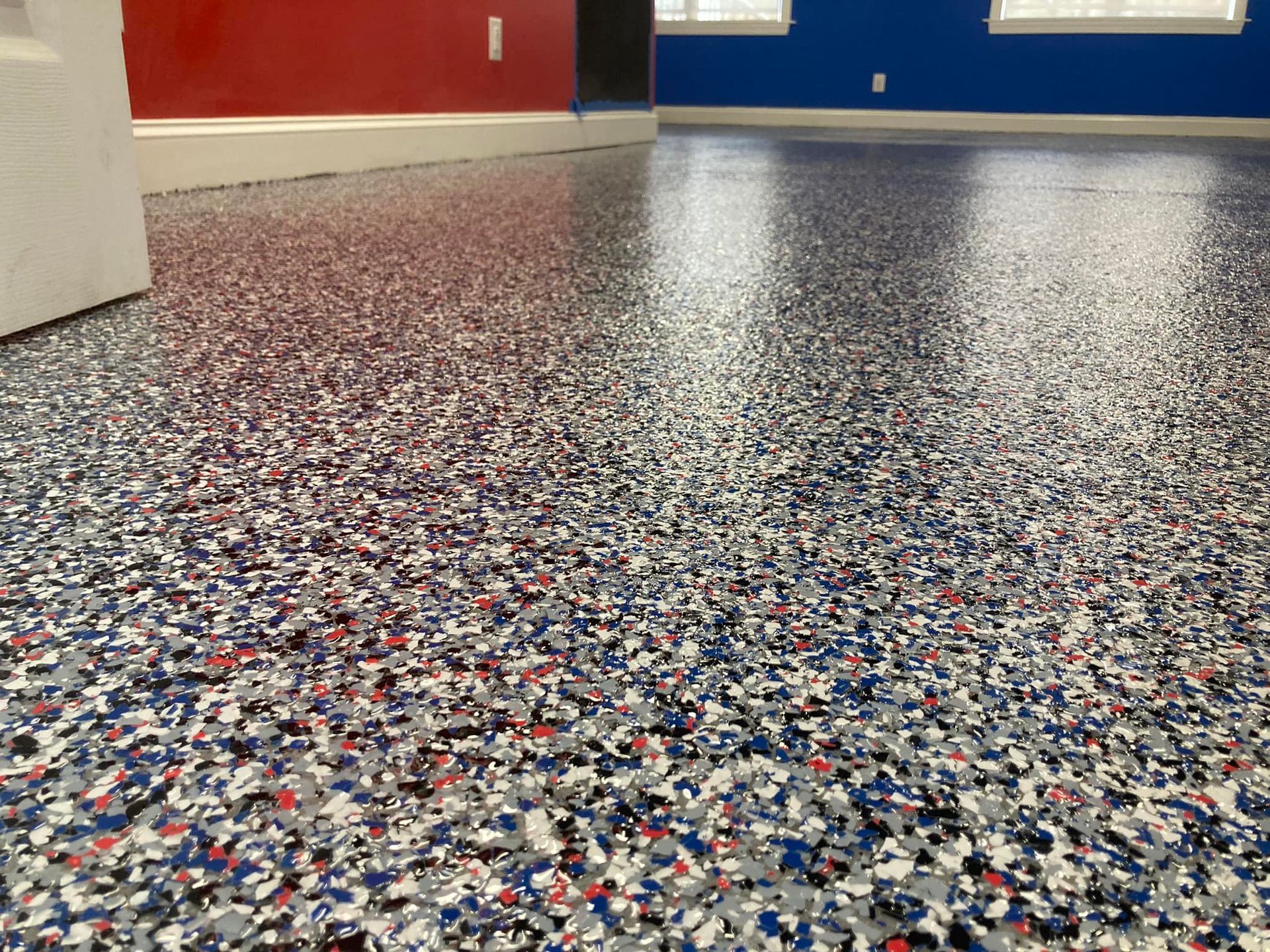 Epoxy-coated floor with red, blue, gray, and white flakes.  The room has red and blue walls.