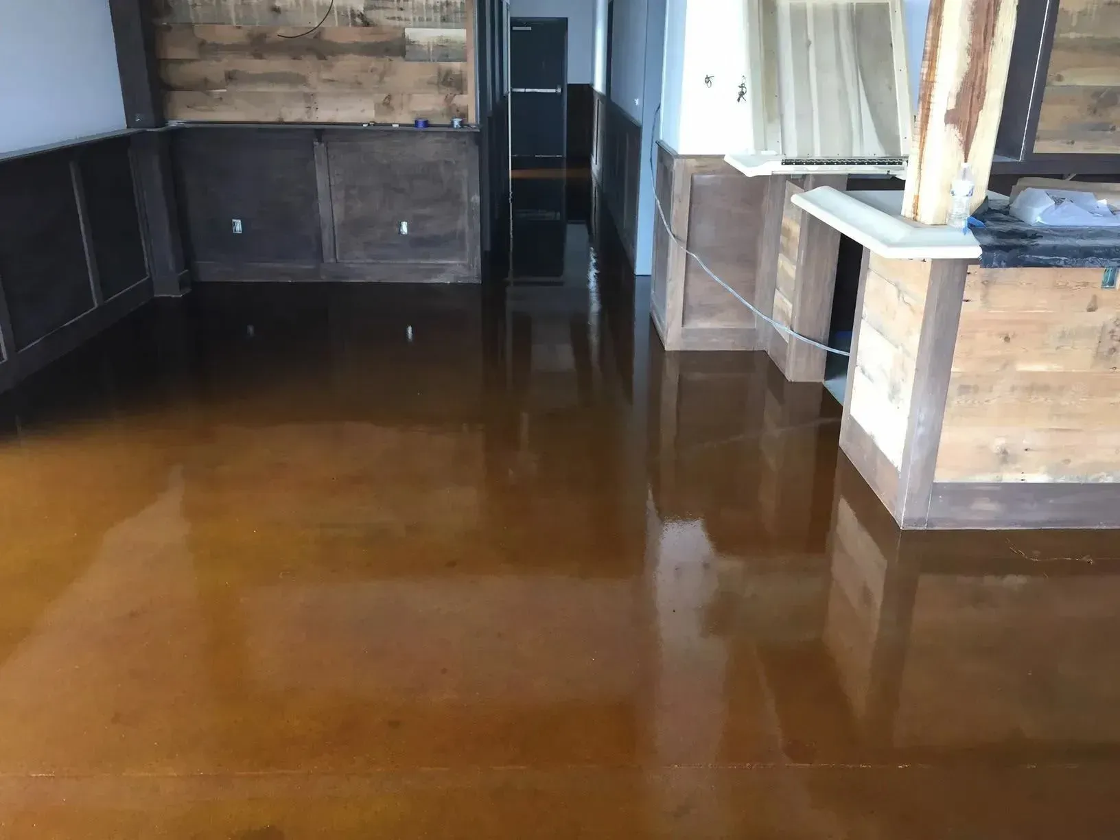 Polished brown concrete floor reflecting interior with wood accents.