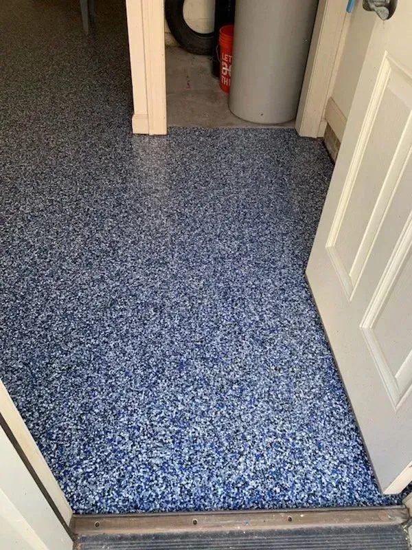 Blue and white speckled epoxy garage floor. View from doorway.