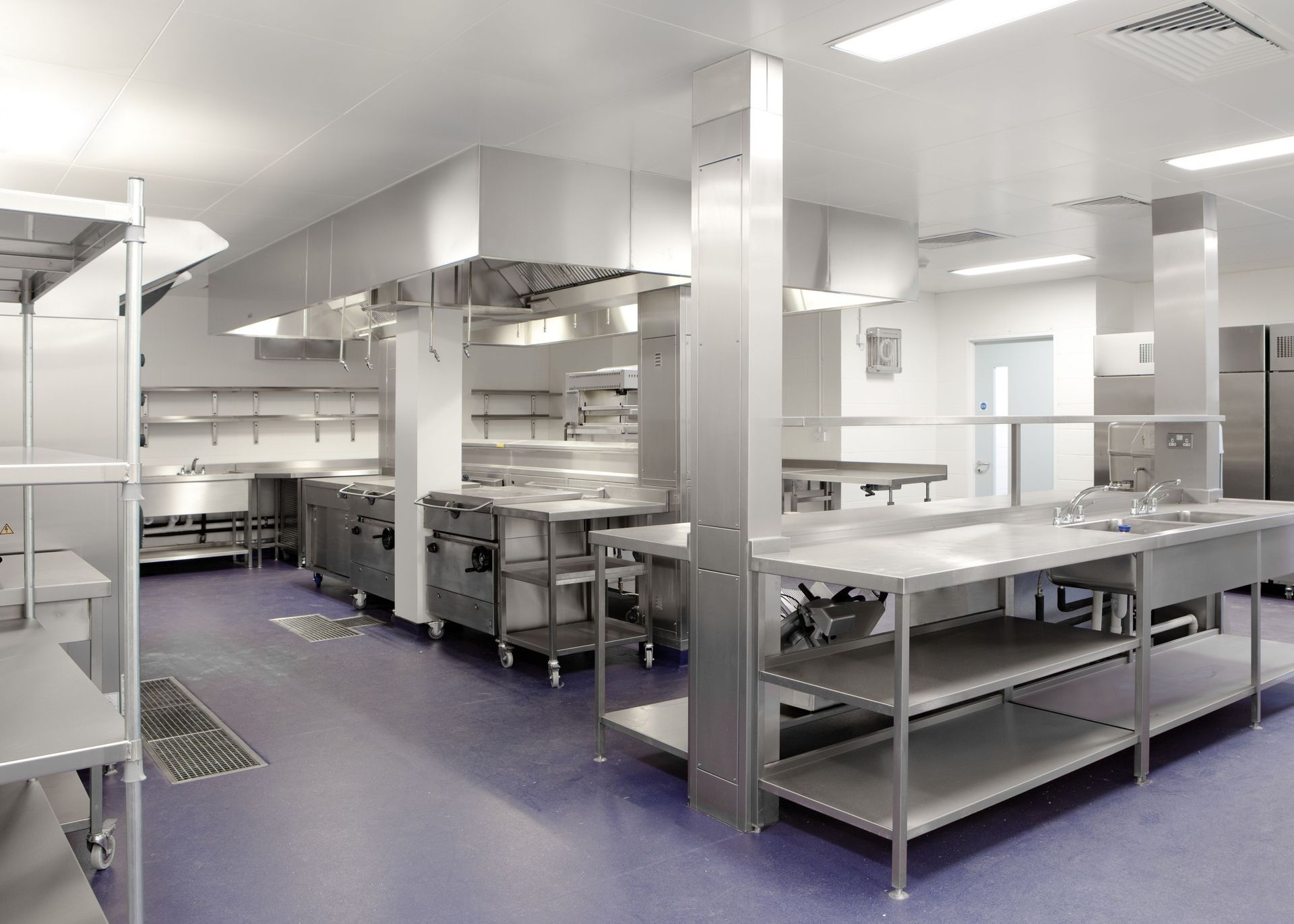 A large kitchen with stainless steel appliances and shelves.