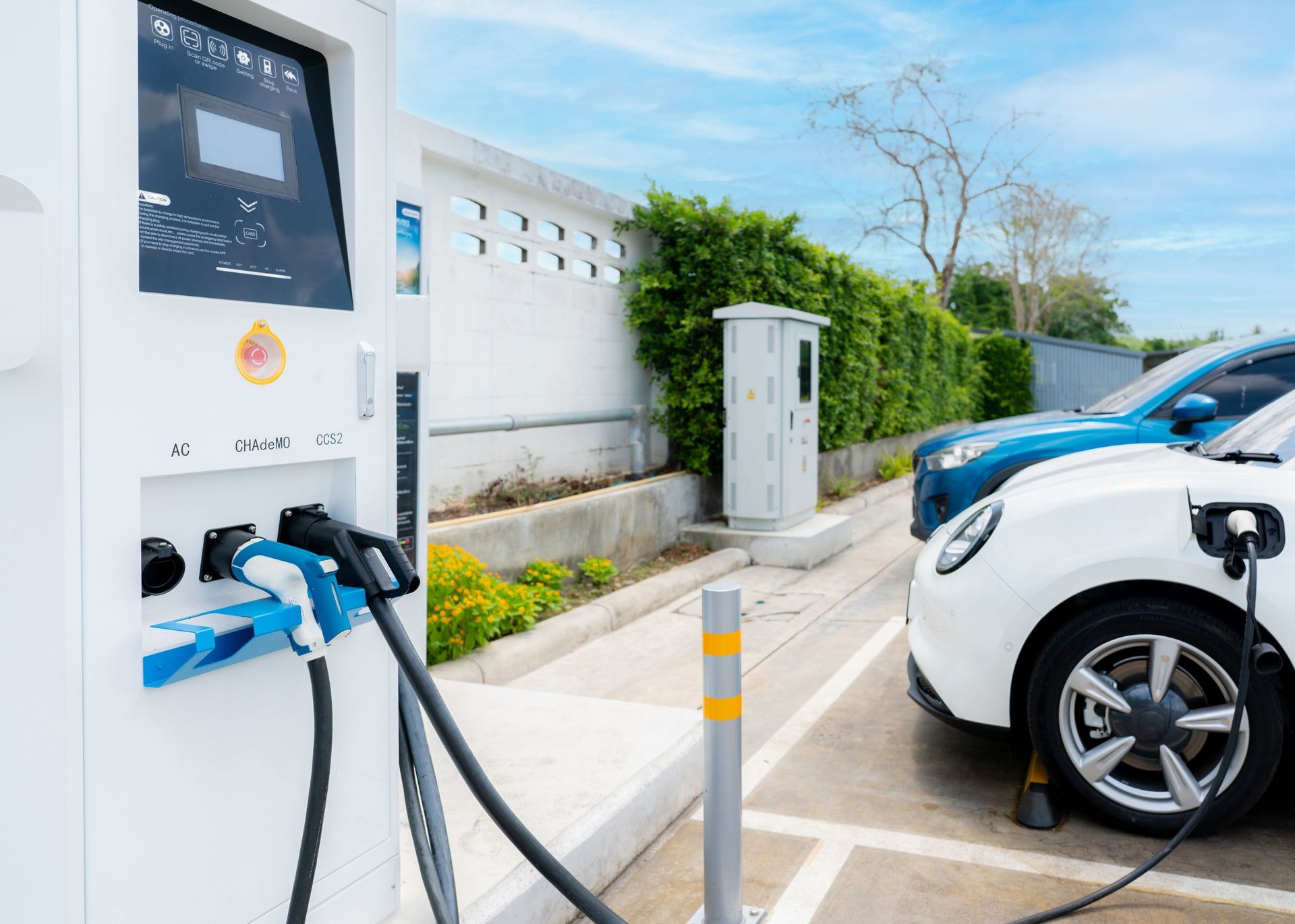 A white electric car is being charged at a charging station.