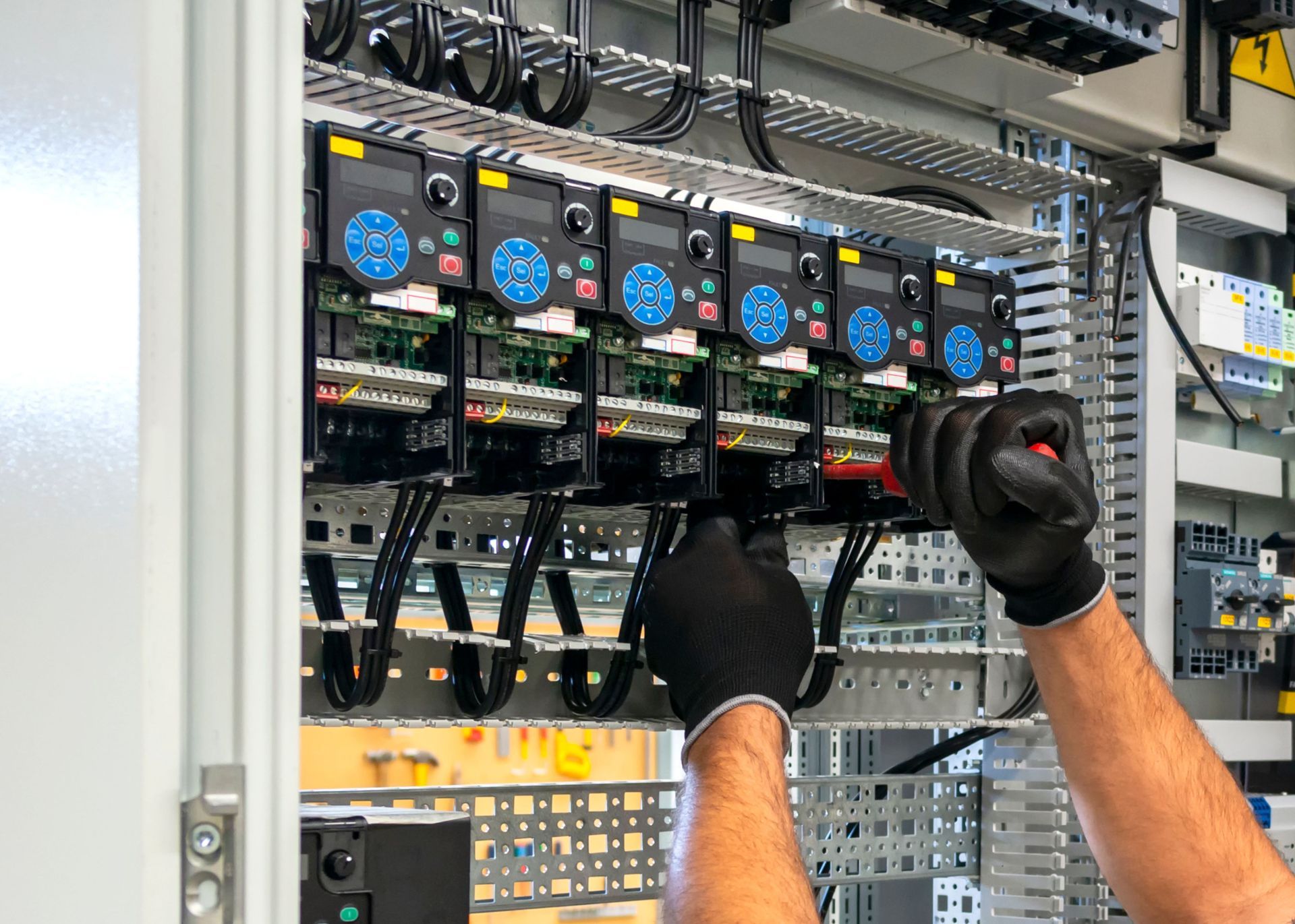 A man is working on a electrical panel in a factory.