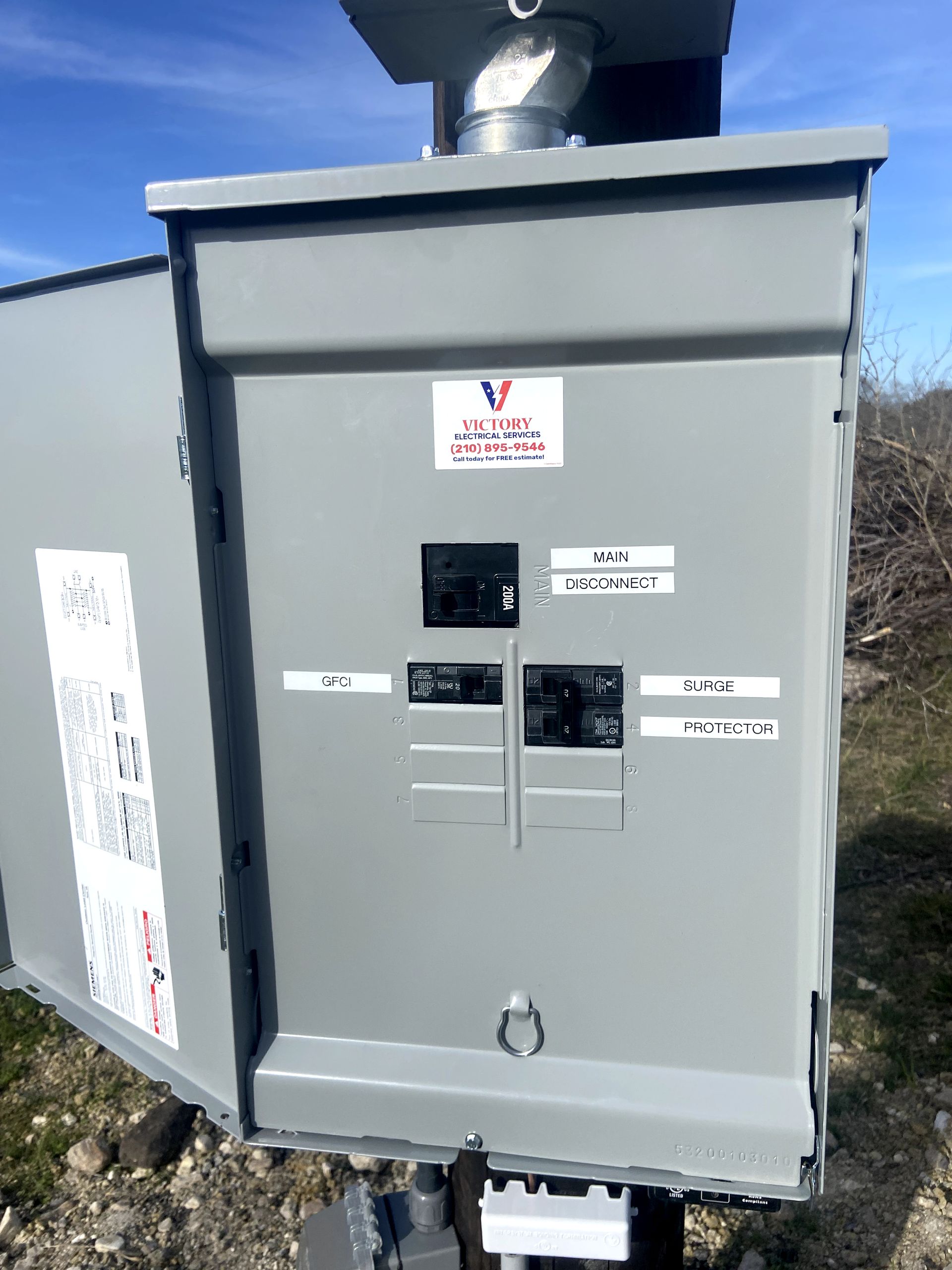 A large electrical box is sitting on top of a pole.