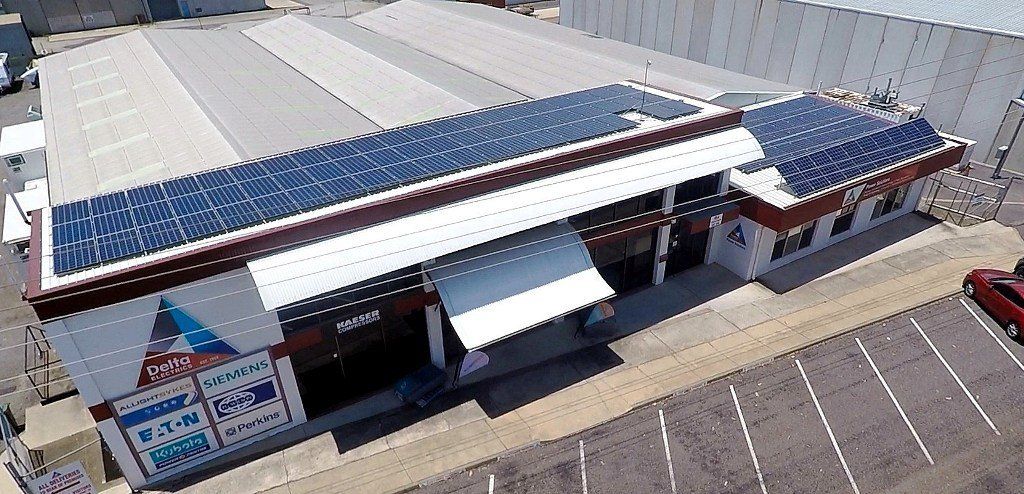 an aerial view of a building with solar panels on the roof
