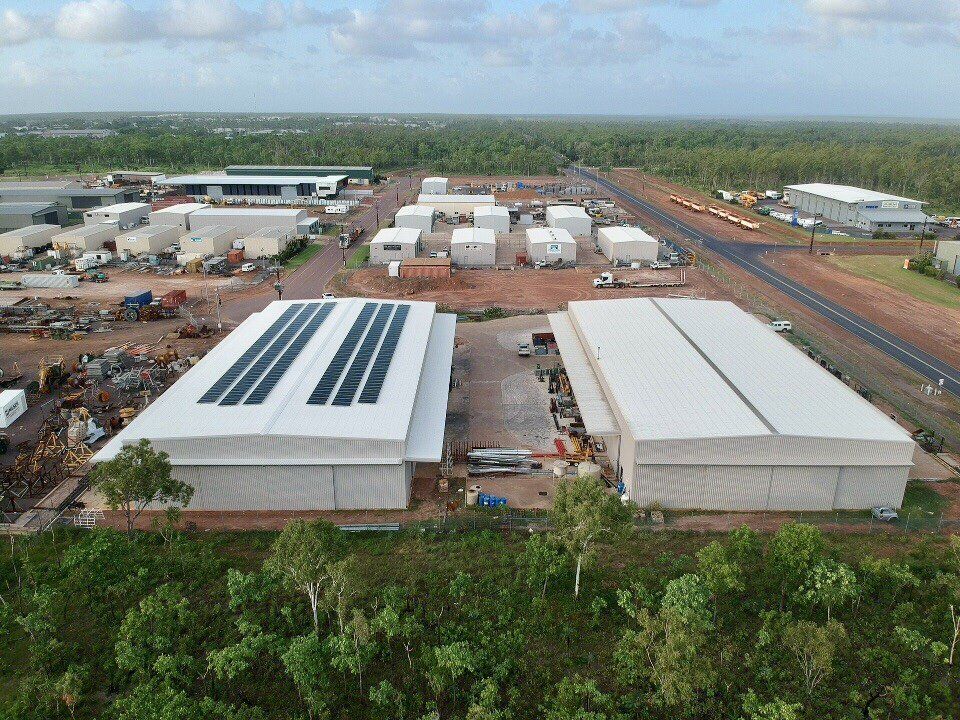 an aerial view of a warehouse with solar panels on the roof .
