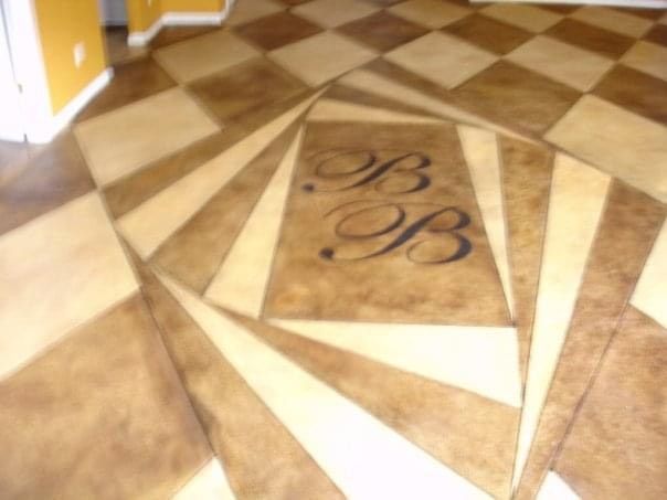 Hand cut concrete tile design using concrete dyes. 