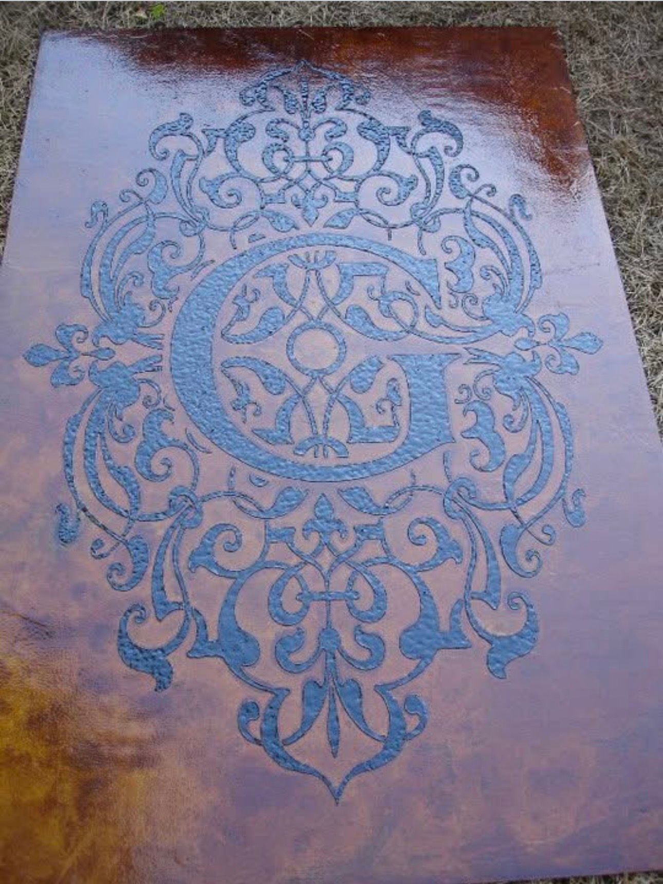 Custom acid stained wall art with textured black accent scroll.