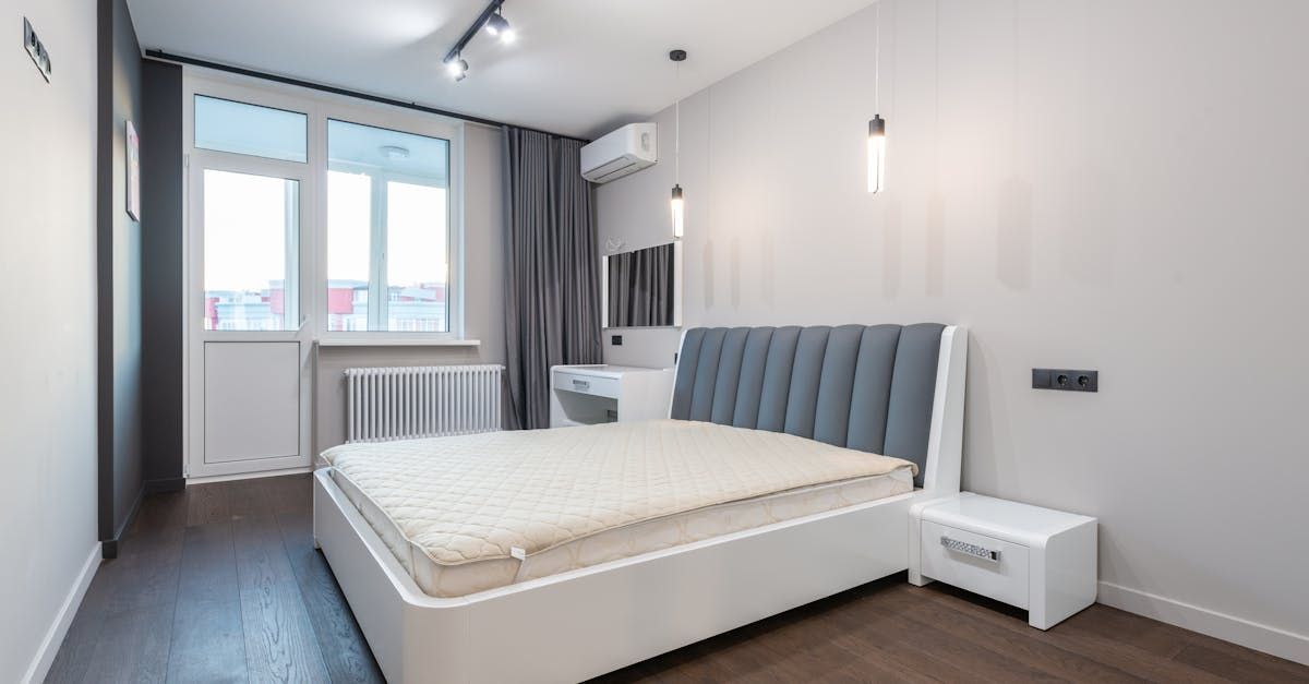 A bedroom with a bed , nightstand , and window.