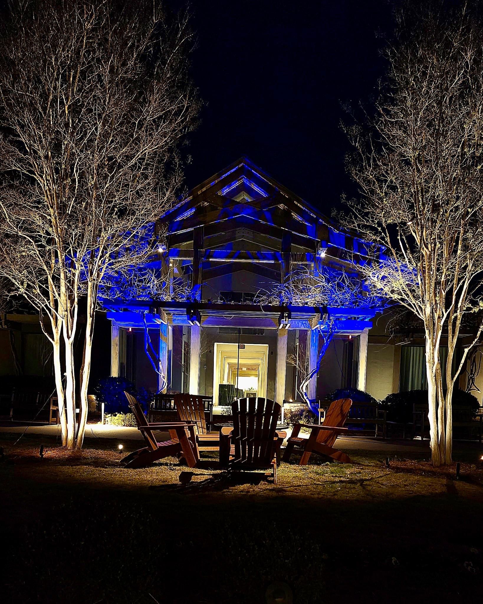 Architectural uplighting with vibrant blue LEDs on a modern building and trees