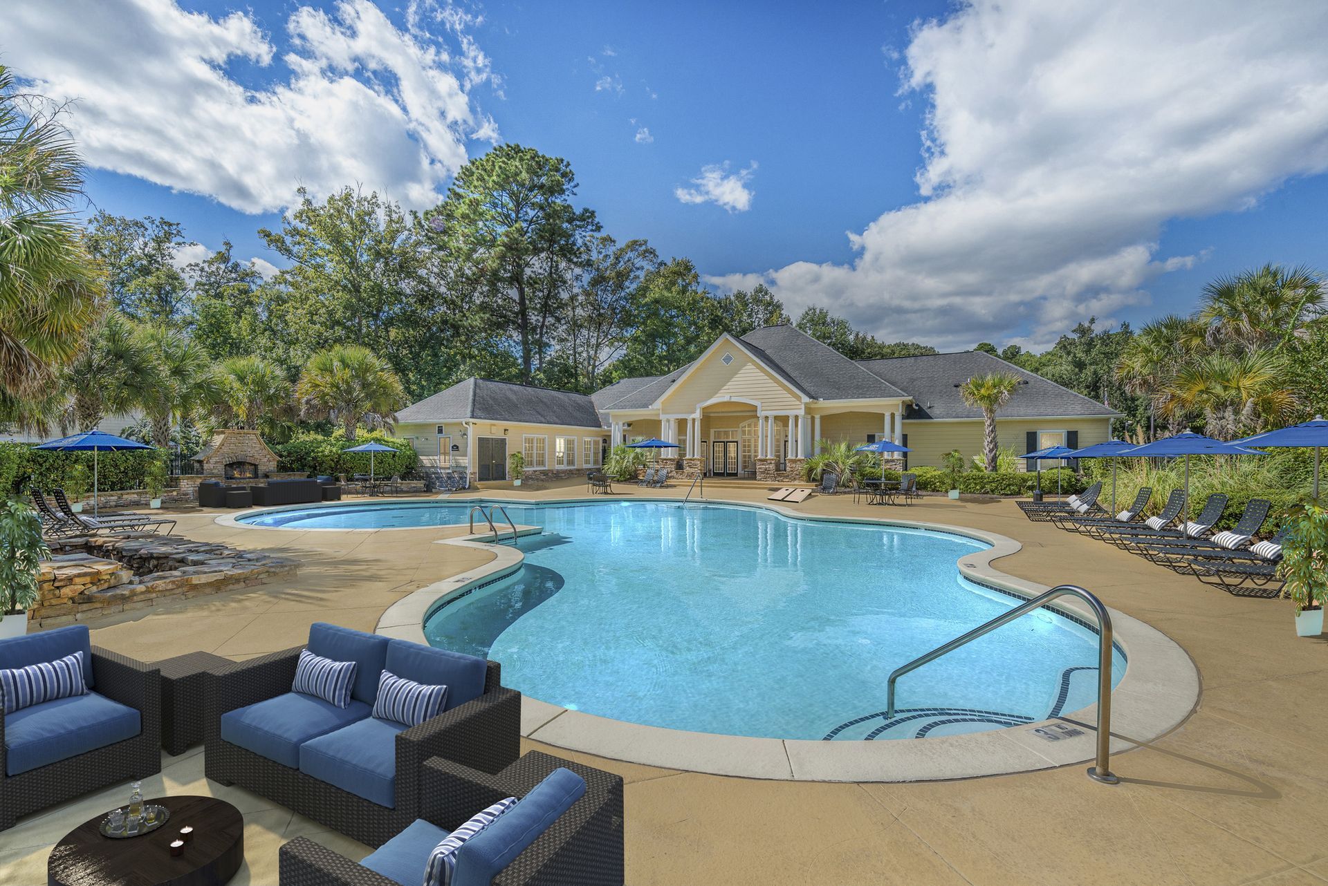 Resort-style pool with lounge chairs and cabanas under a blue sky at Walden at Chatham Center Apartments in Savannah, GA.