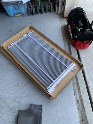 A radiator is sitting on top of a cardboard box in a garage.