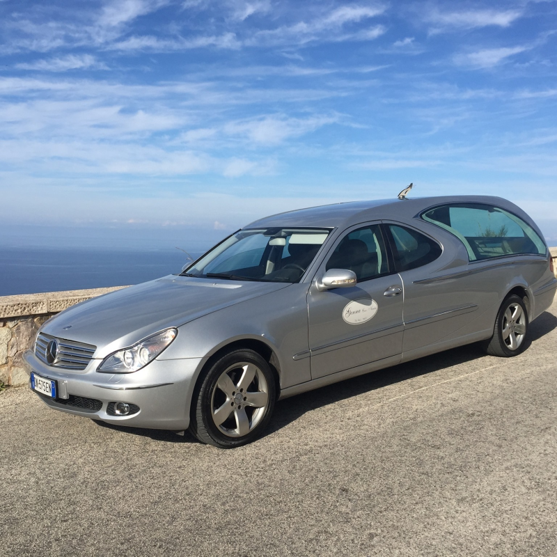 A silver car is parked on the side of the road