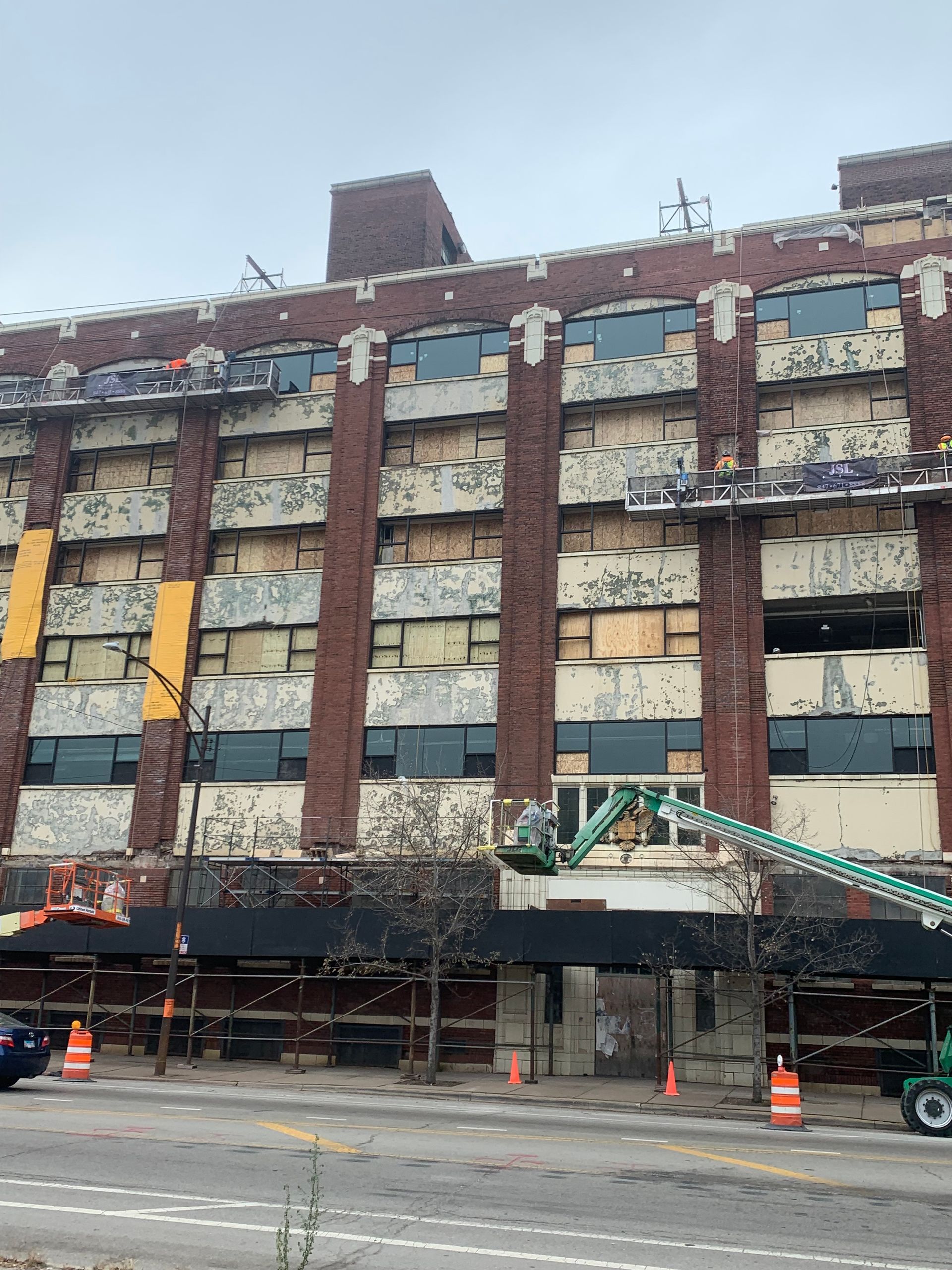 A large brick building with a lot of windows is being demolished.