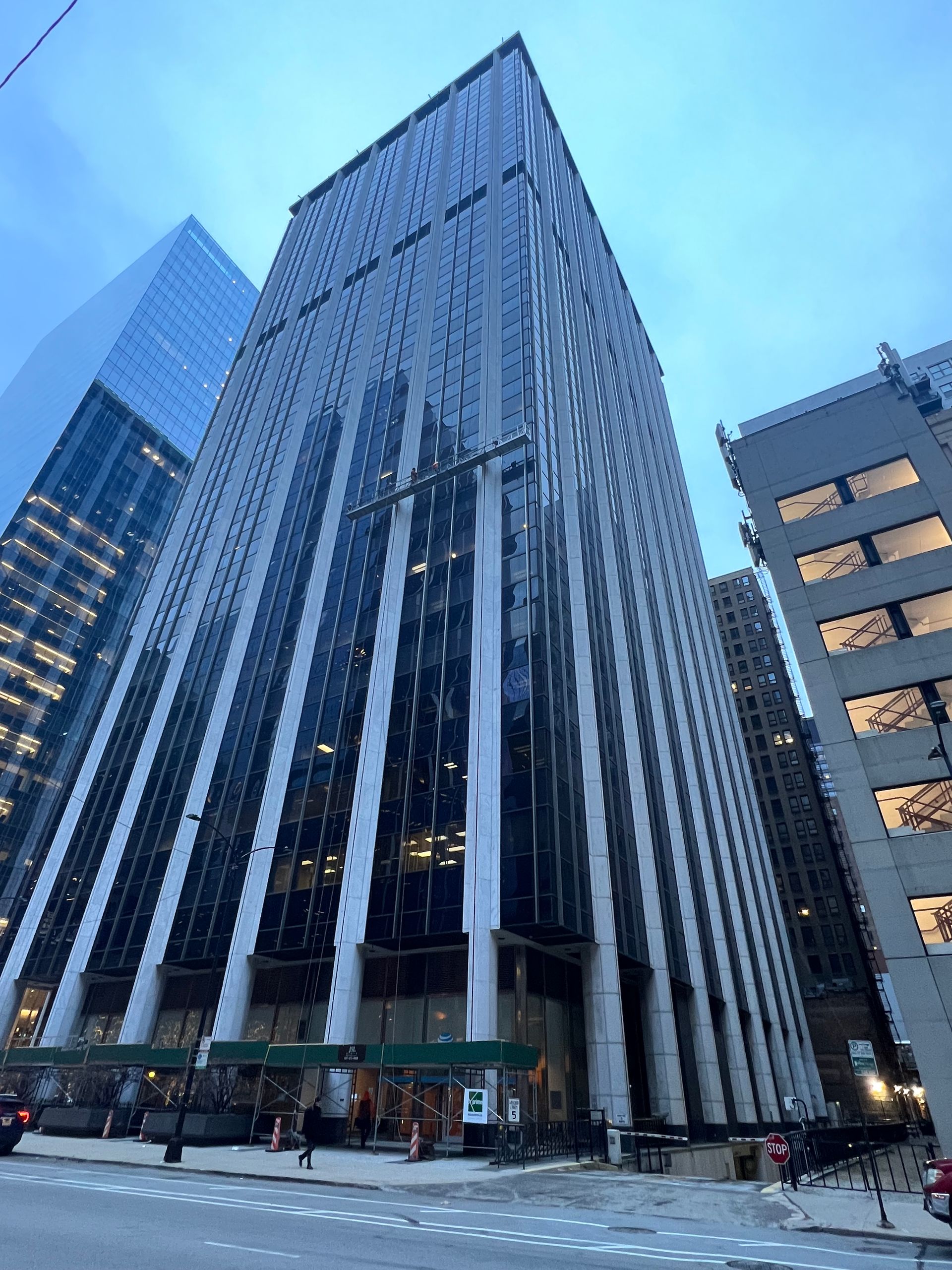 A tall building with a lot of windows is in the middle of a city.
