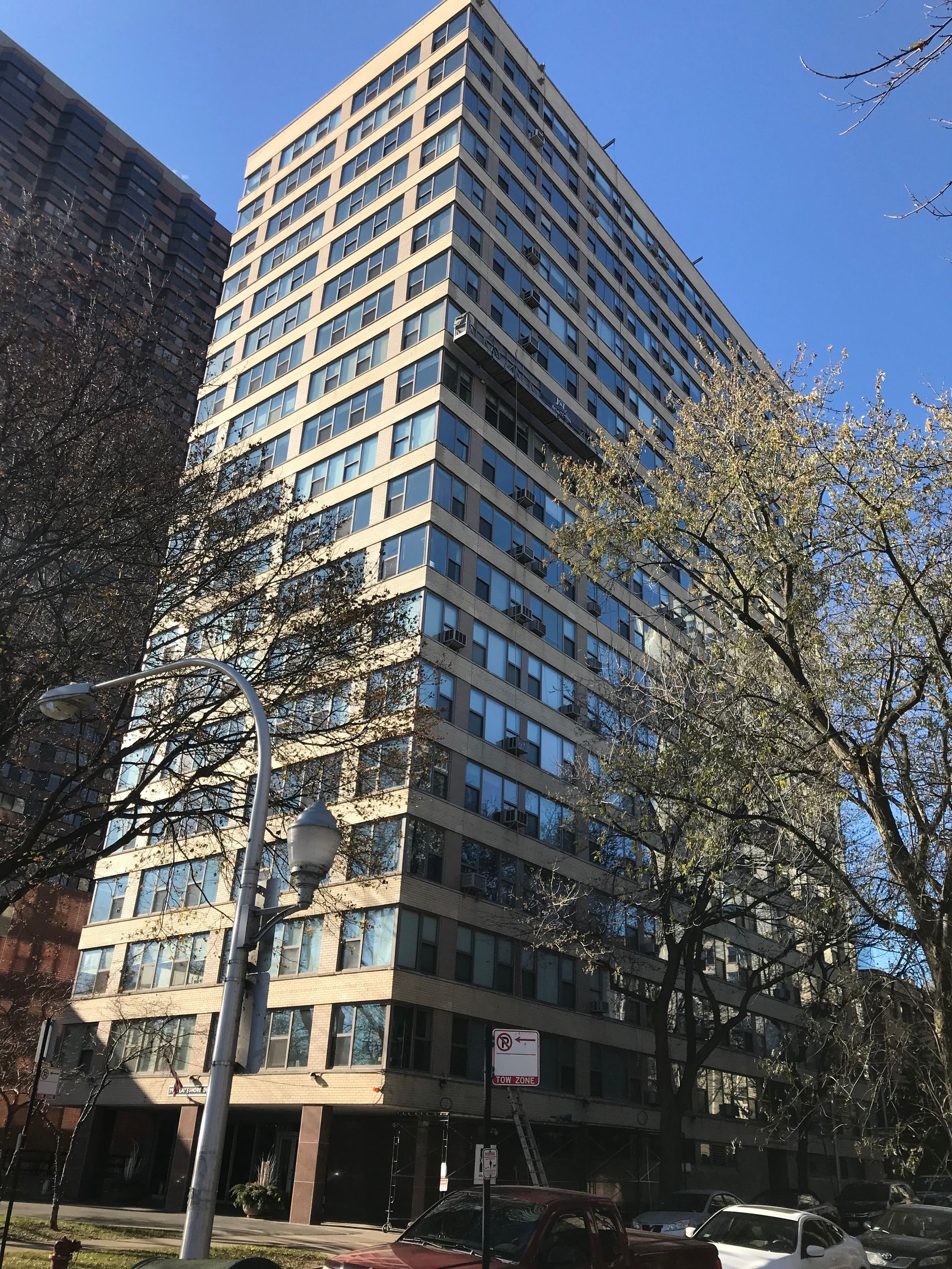 A tall building with a lot of windows and trees in front of it