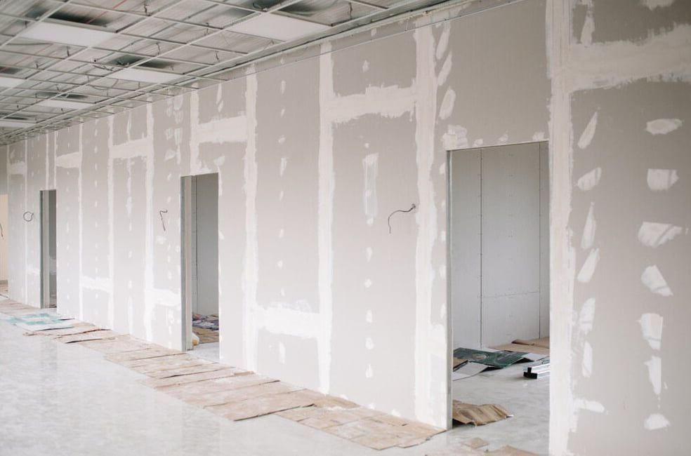 An Unfinished Interior Corridor Under Construction Featuring Bare Drywall — HJK Plastering In Lennox Head, NSW