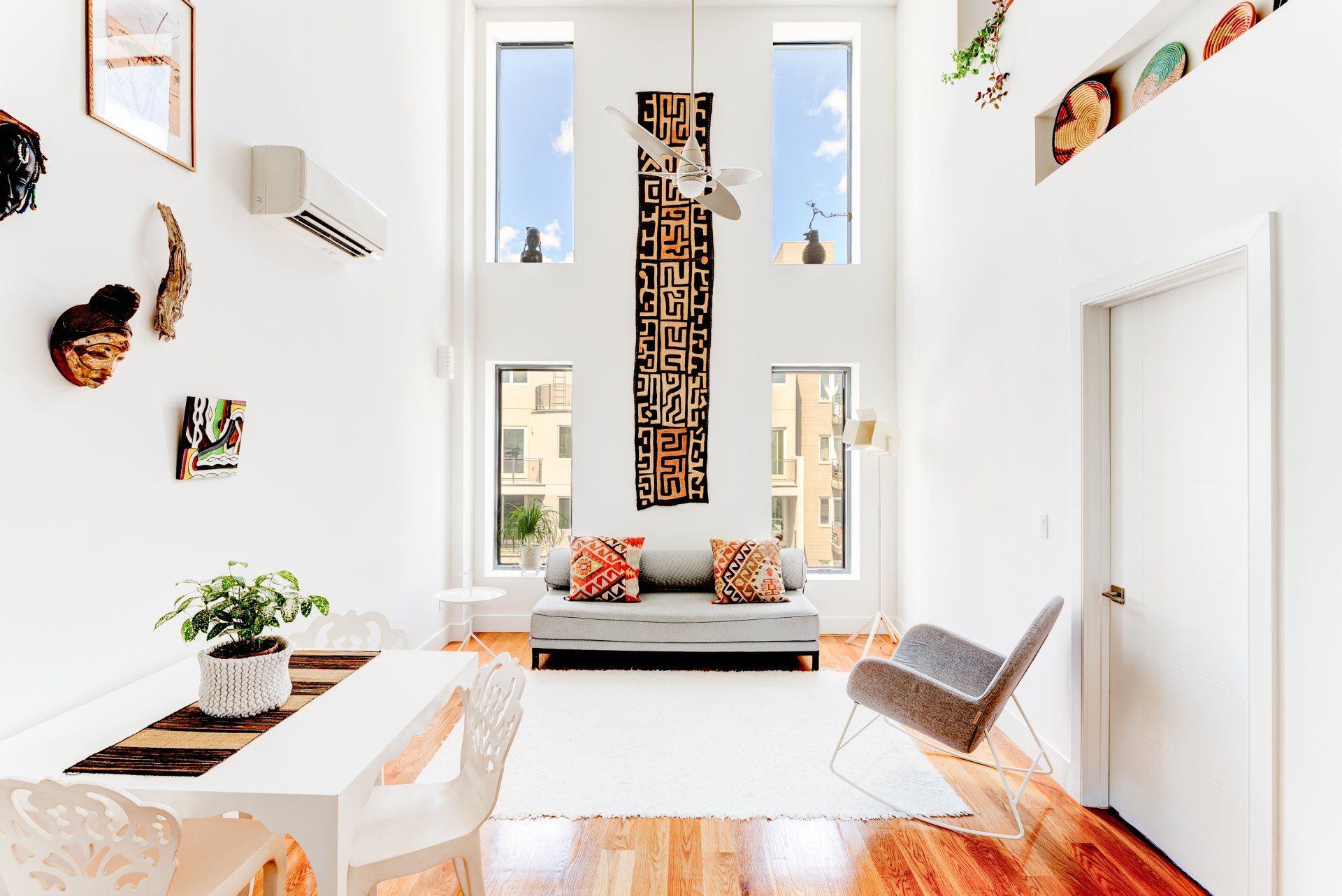 A living room with a couch , chair , table and windows.