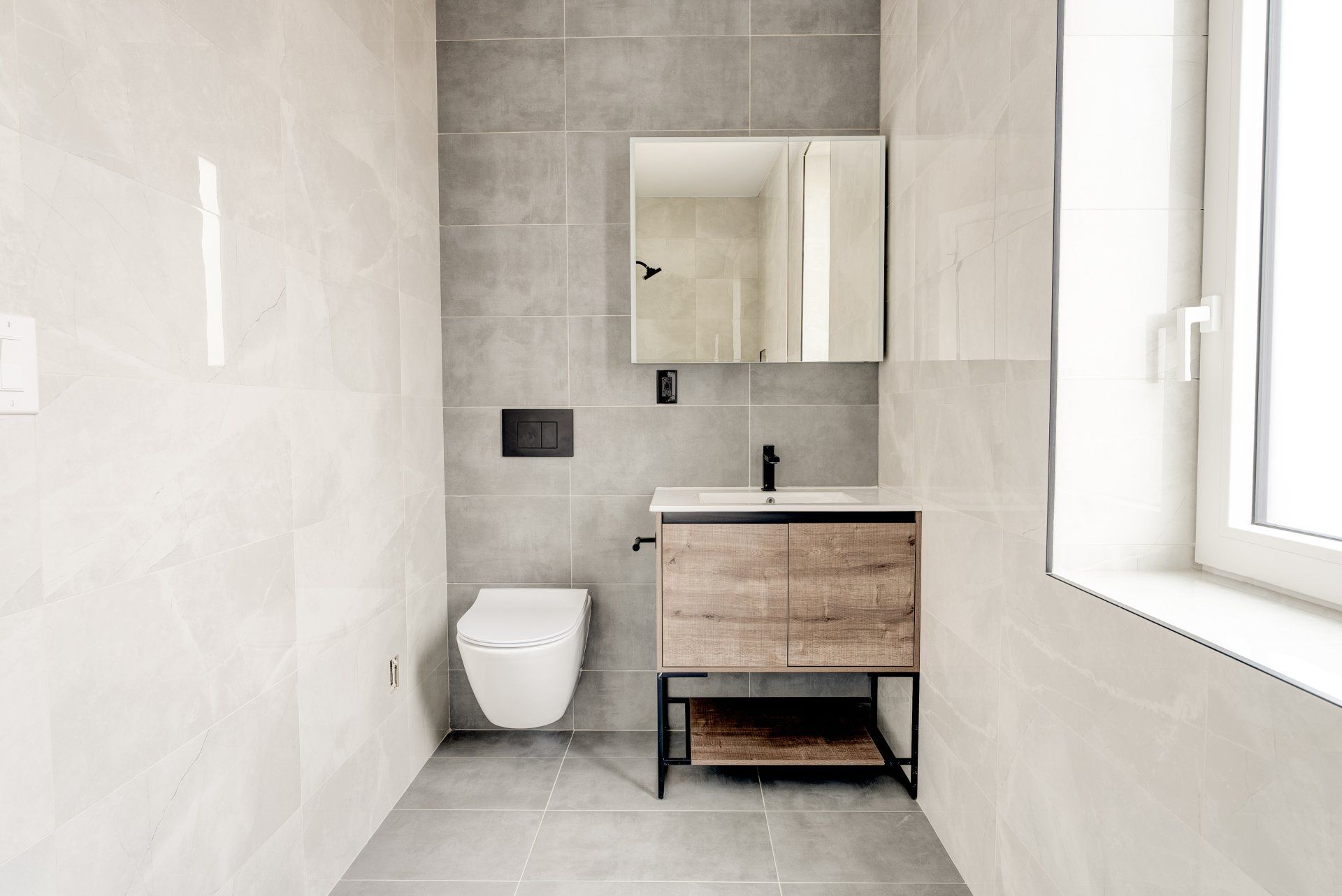 A bathroom with a toilet , sink and mirror