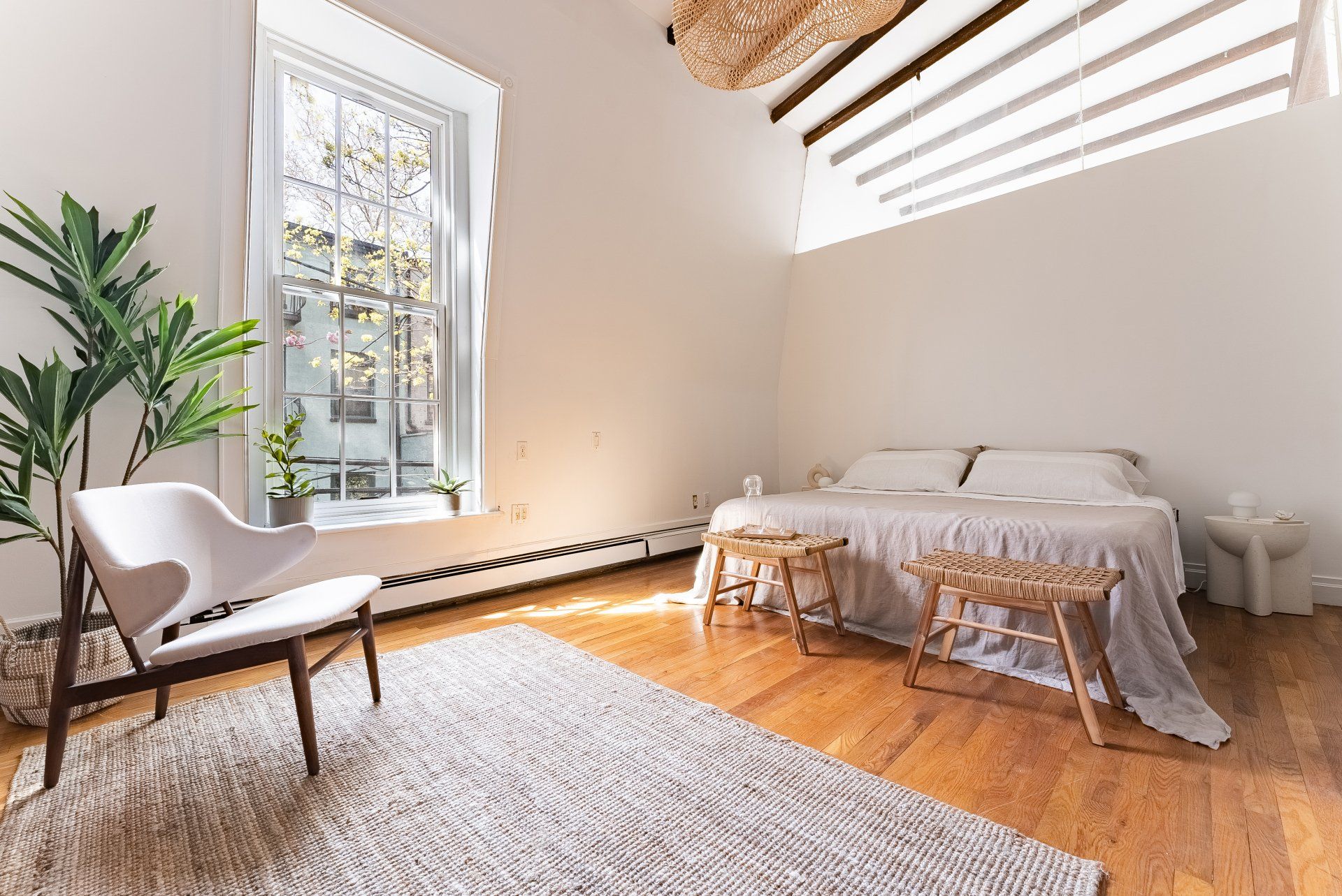 A bedroom with a bed , chair , rug and window.