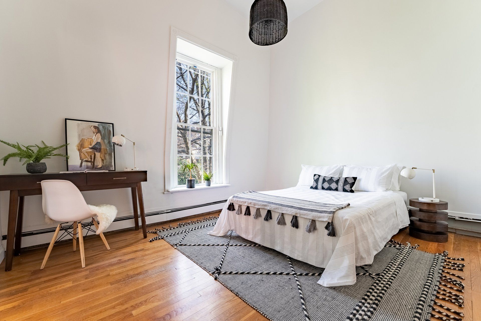 A bedroom with a bed , desk , chair and rug.