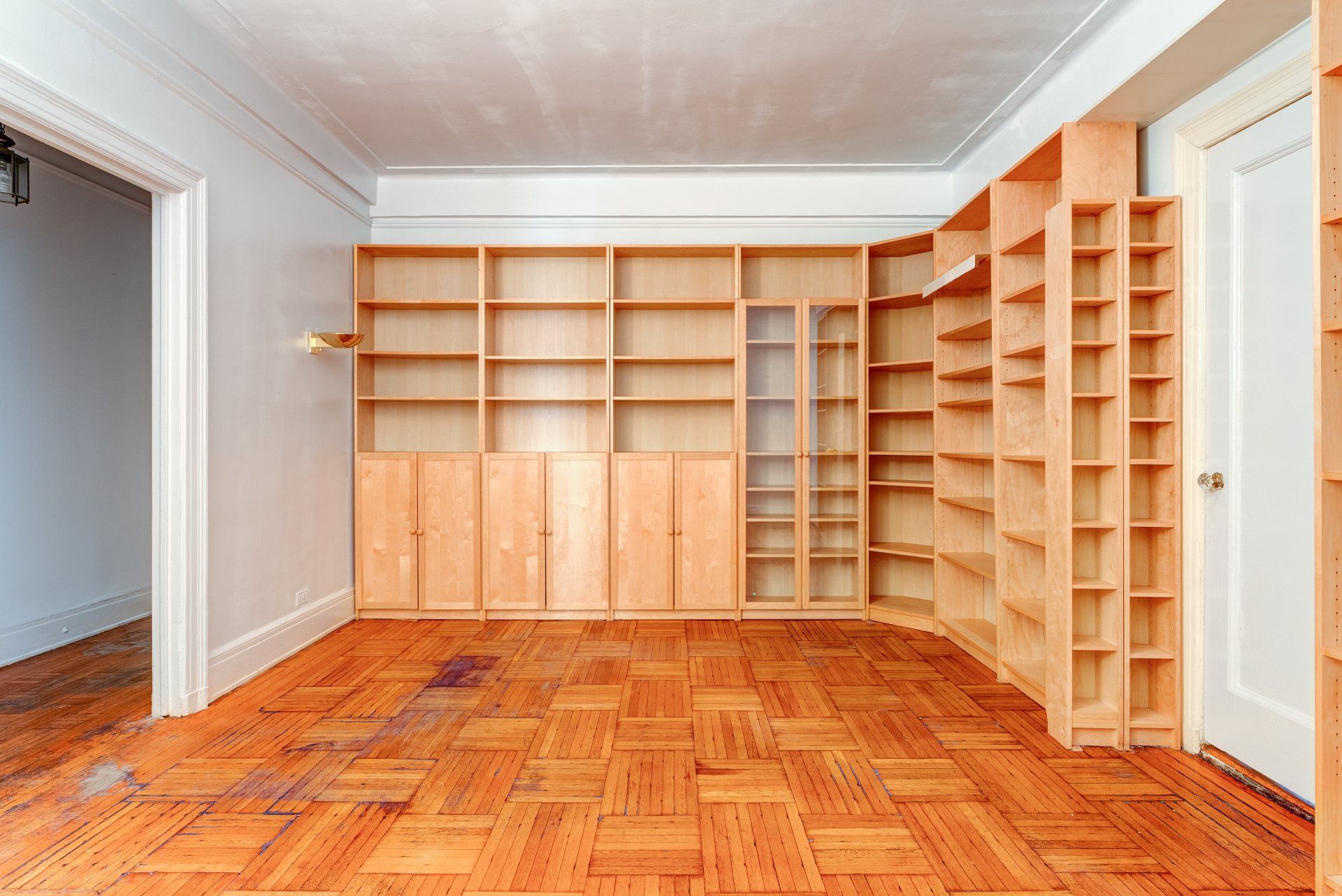 An empty room with wooden shelves and a wooden floor.
