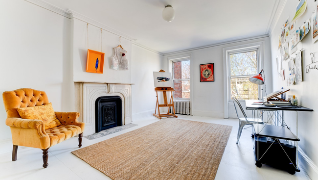 A living room with a yellow chair and a fireplace