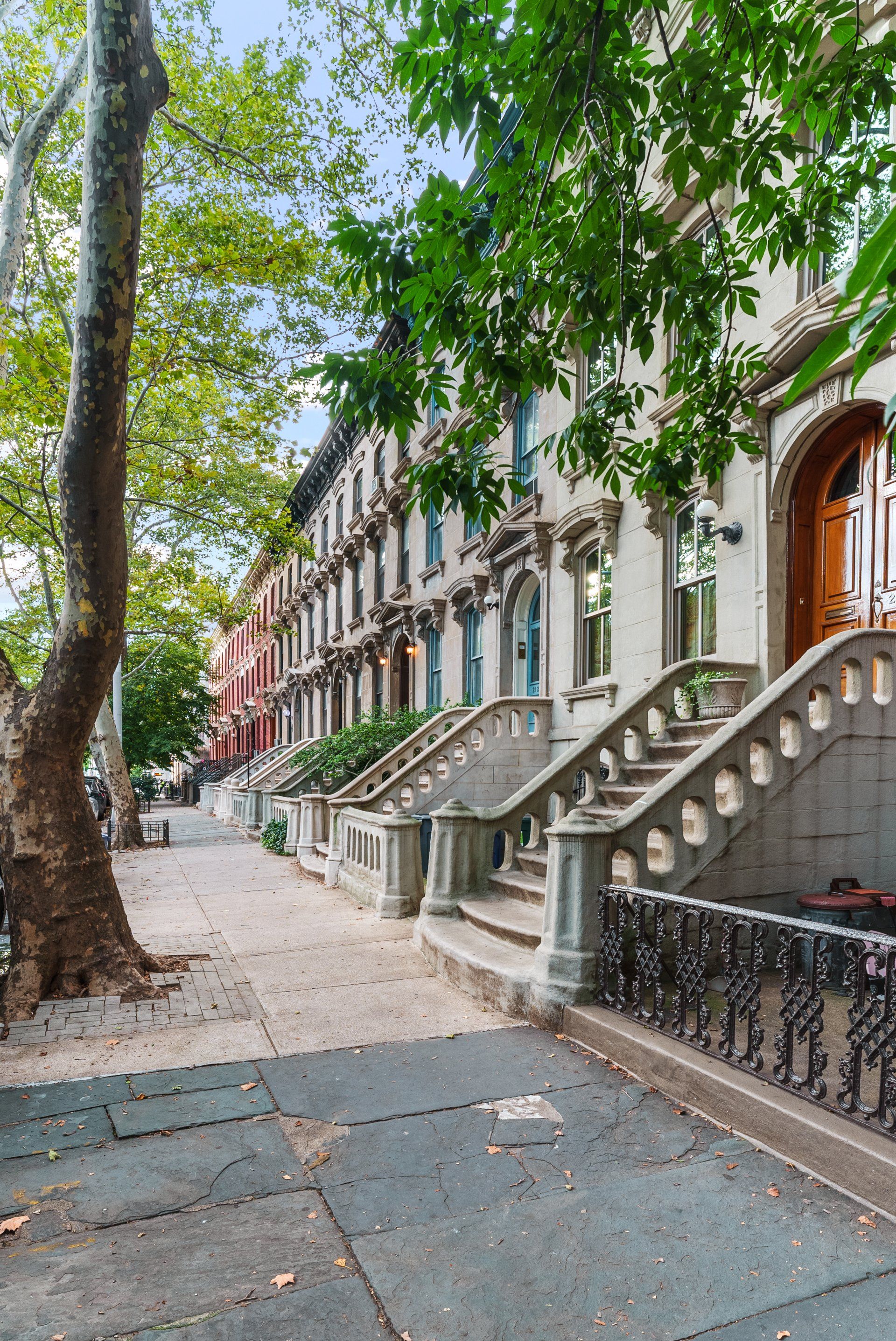 A row of houses with stairs leading up to the front door.