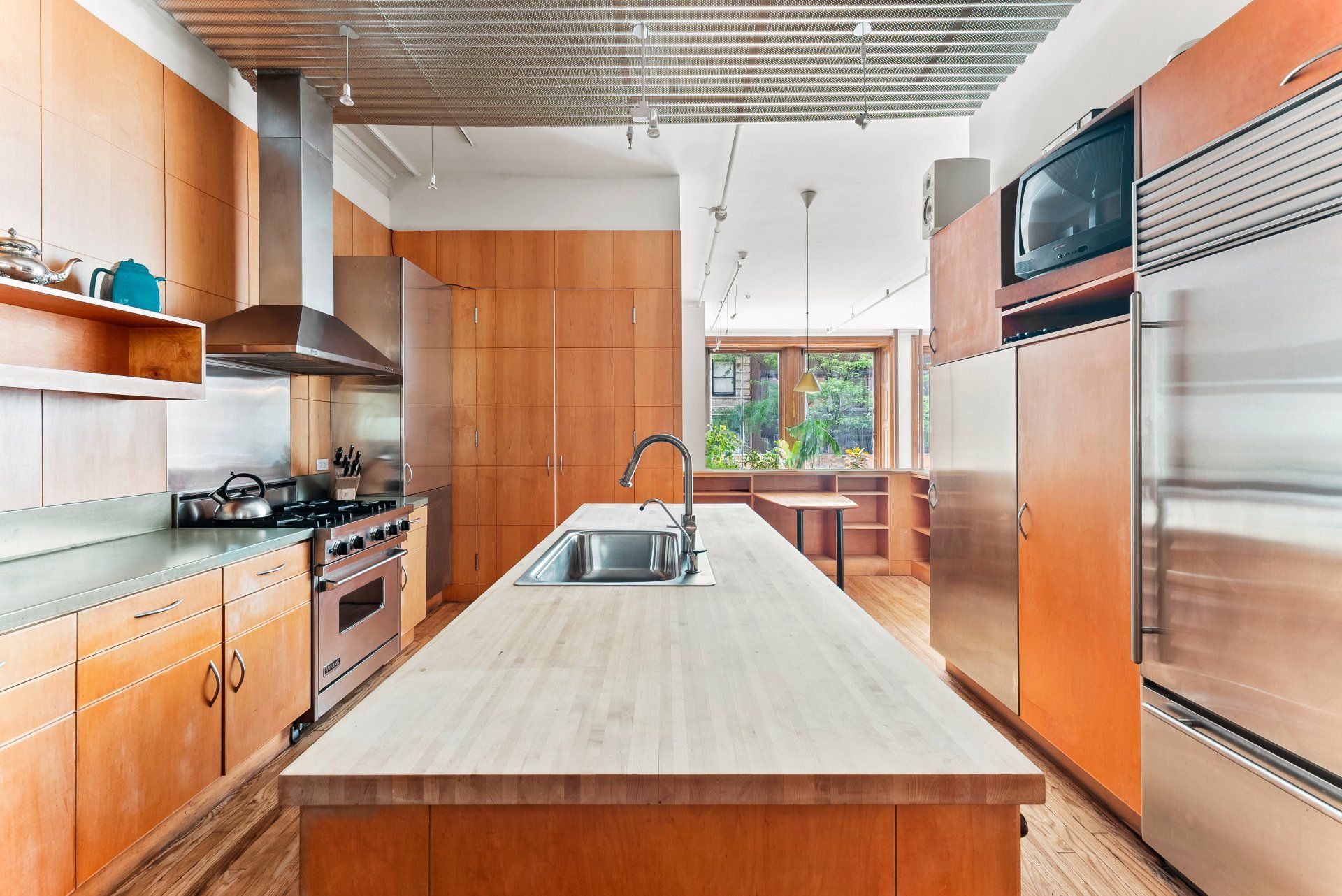 A kitchen with stainless steel appliances and wooden cabinets