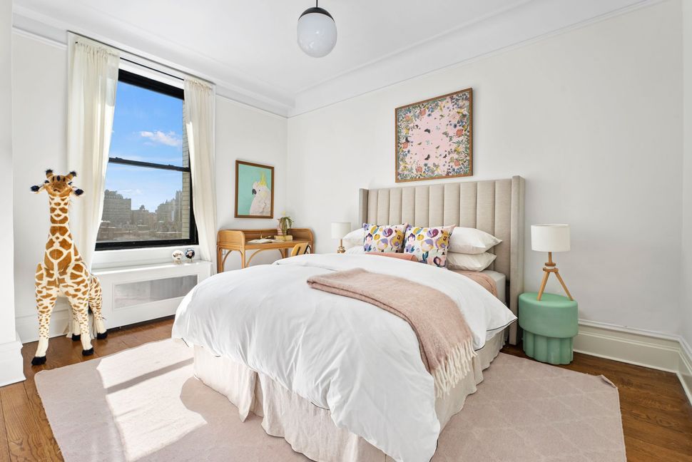 A bedroom with a large bed and a giraffe on the wall.