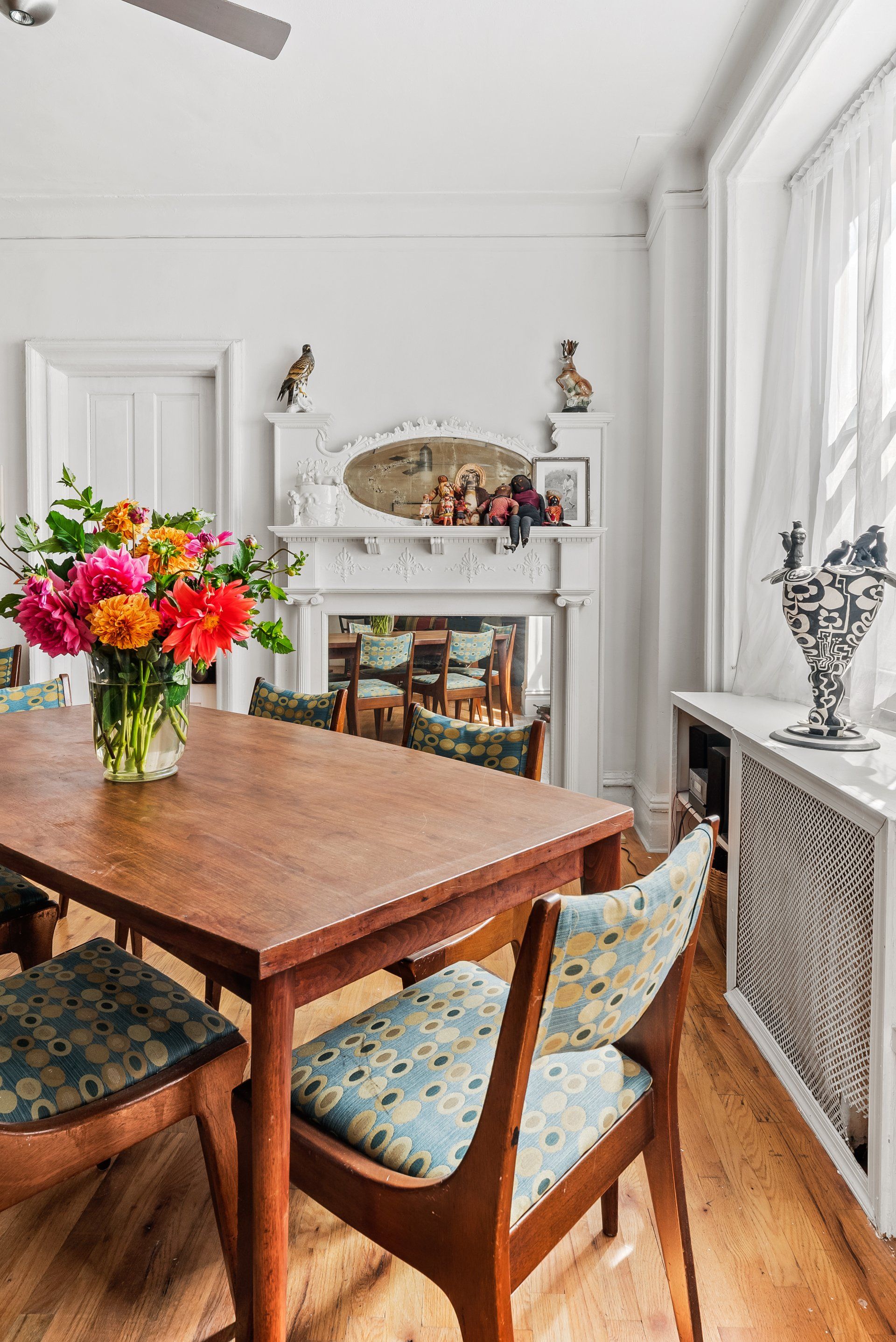 There is a vase of flowers on the table in the dining room.