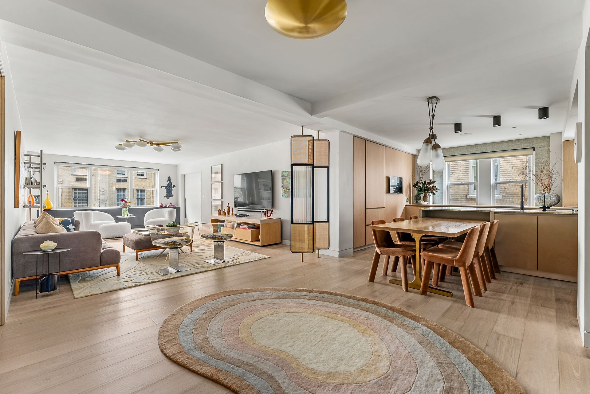 There is a rug in the middle of the living room and dining room.
